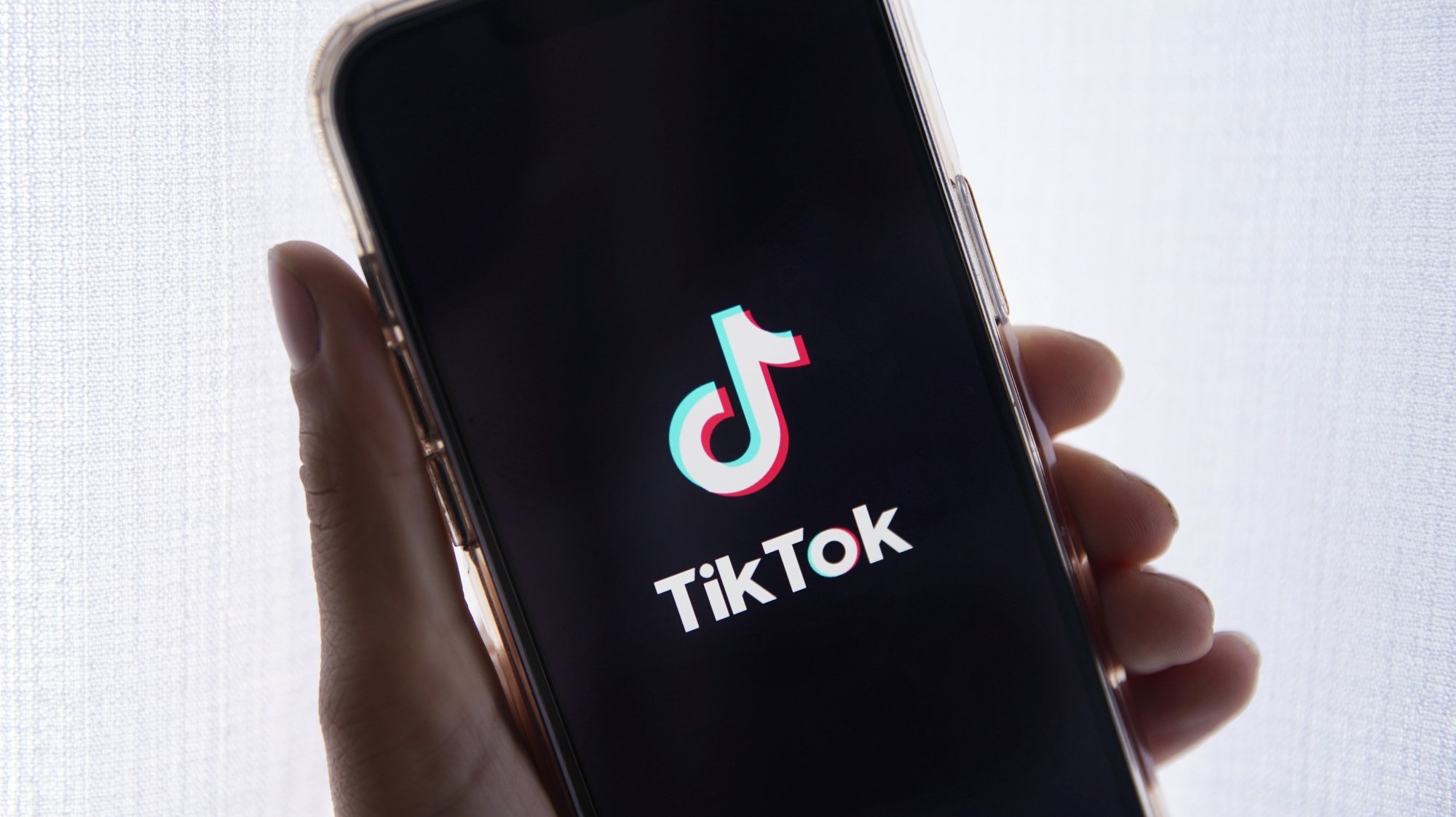 epa10635388 In this photo illustration a person holds up a cell phone with the TikTok logo displayed in Los Angeles, California, USA, 17 May 2023. Govenor Greg Gianforte of Montana signed a measure that bans the TikTok app in the state.  EPA/CAROLINE BREHMAN