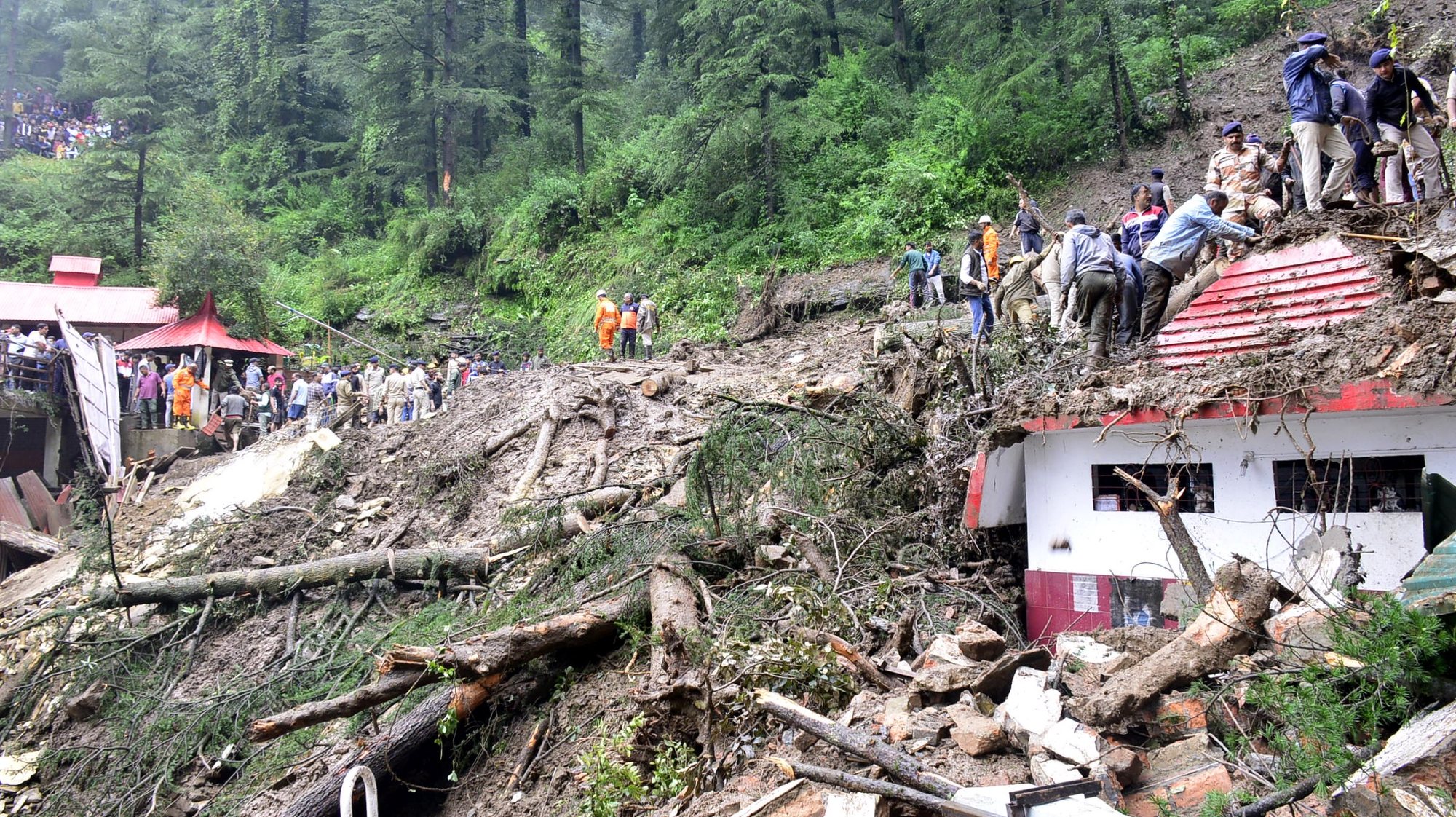 epa10799933 Rescue workers gather at the scene after a temple collapsed due to a landslide near Shimla, Himachal Pradesh, northern India, 14 August 2023. At least nine nine people were killed inside the Shiv temple when the structure collapsed under a landslide triggered by heavy rains, Chief Minister Sukhvinder Singh Sikhu confirmed.  EPA/STR