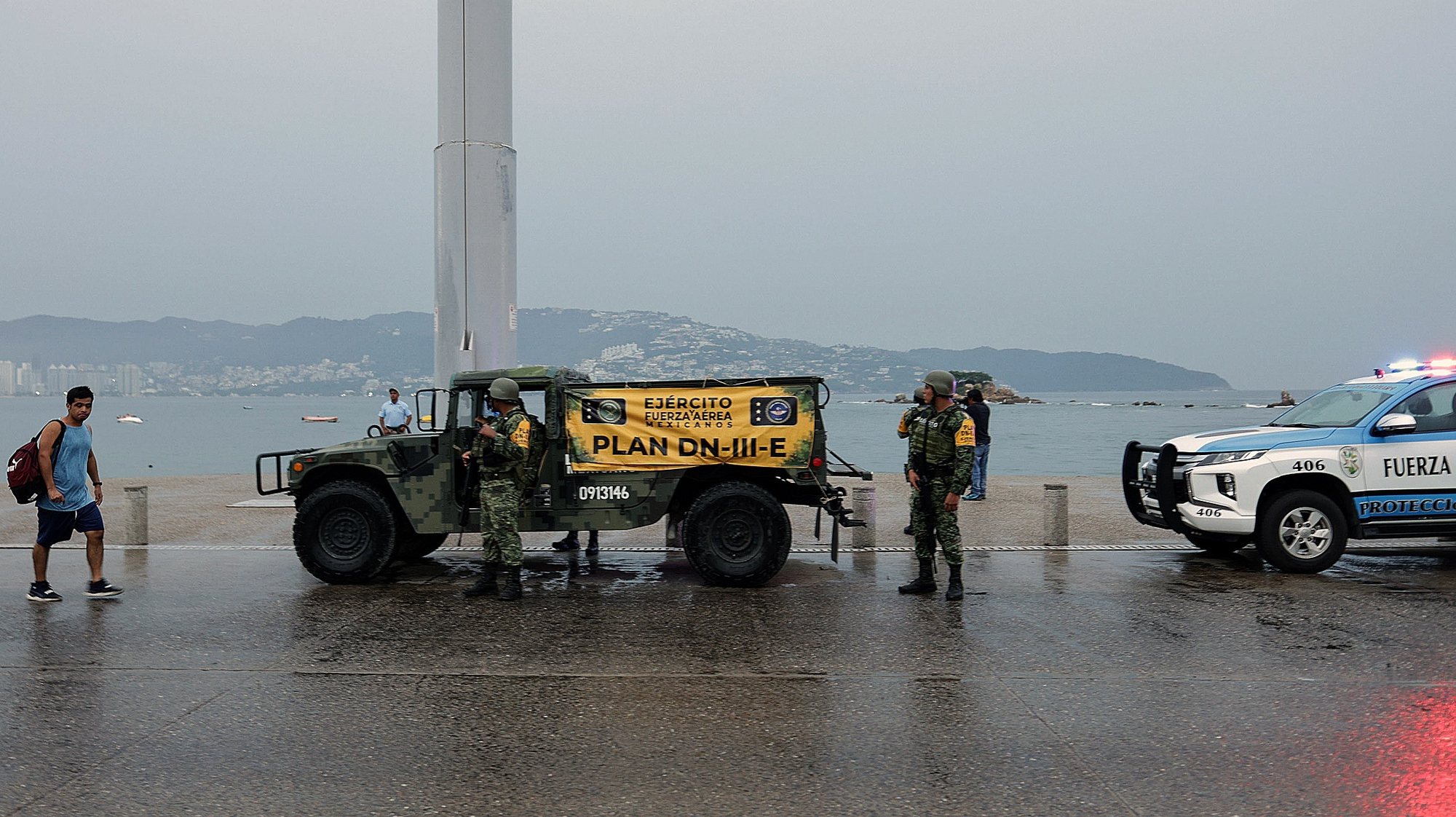 epa10937387 Soldiers of the Mexican Army stand guard as part of the measures against the imminent arrival of Hurricane Otis, in Acapulco, Mexico, 24 October 2023. Hurricane Otis, which is moving through the Mexican Pacific towards the state of Guerrero, has rapidly intensified to category 4 on the Saffir-Simpson scale and may reach category 5 in the next few hours, the National Meteorological Service (SMN) reported this 24 October.  EPA/David Guzman
