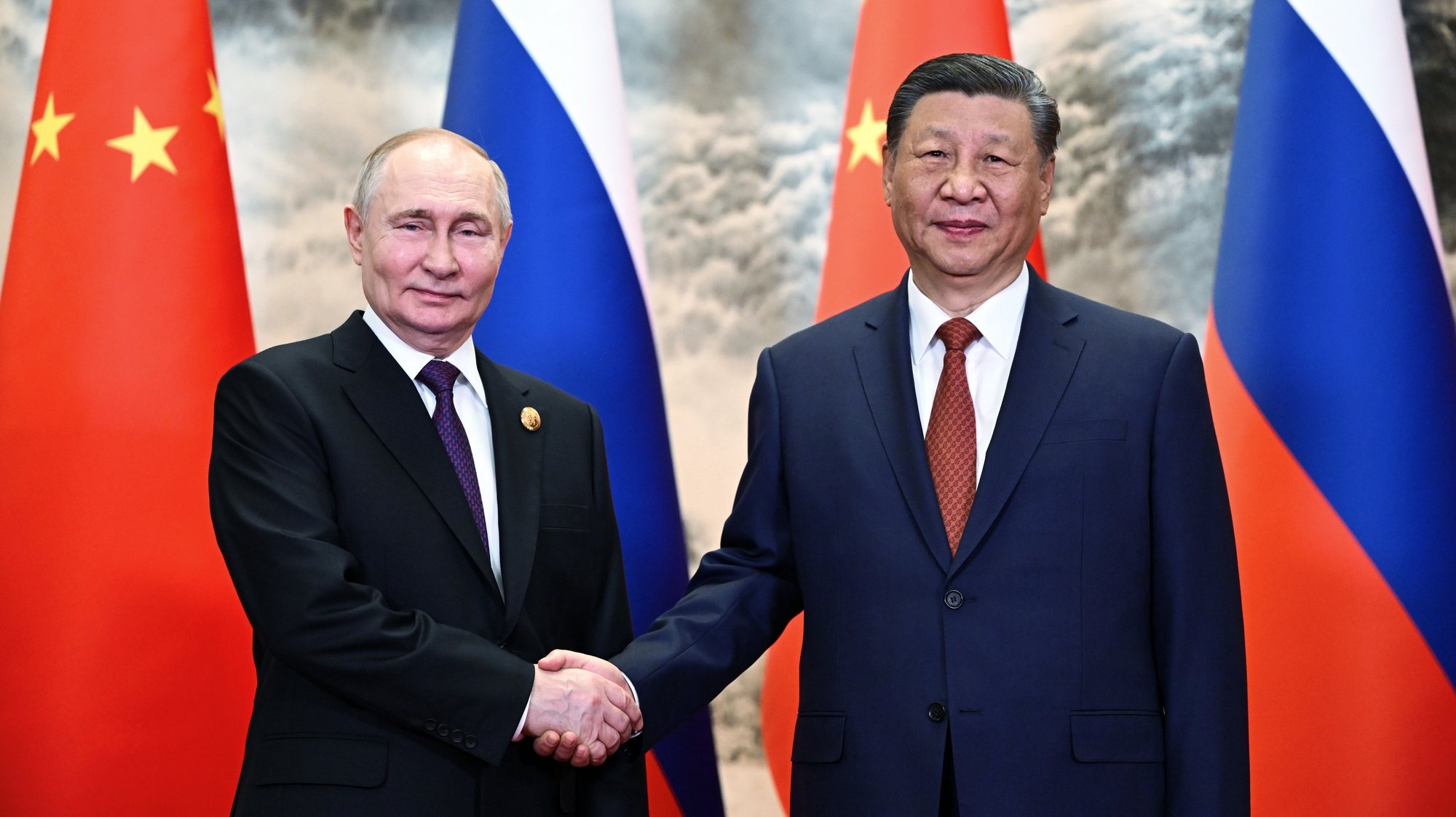 epa11343937 Russian President Vladimir Putin (L) and Chinese President Xi Jinping shake hands as they pose for photos before a meeting in narrow format at the Great Hall of the People in Beijing, China, 16 May 2024. The Russian president is on an official visit to China on 16 and 17 May.  EPA/SERGEY GUNEEV / SPUTNIK / KREMLIN POOL MANDATORY CREDIT