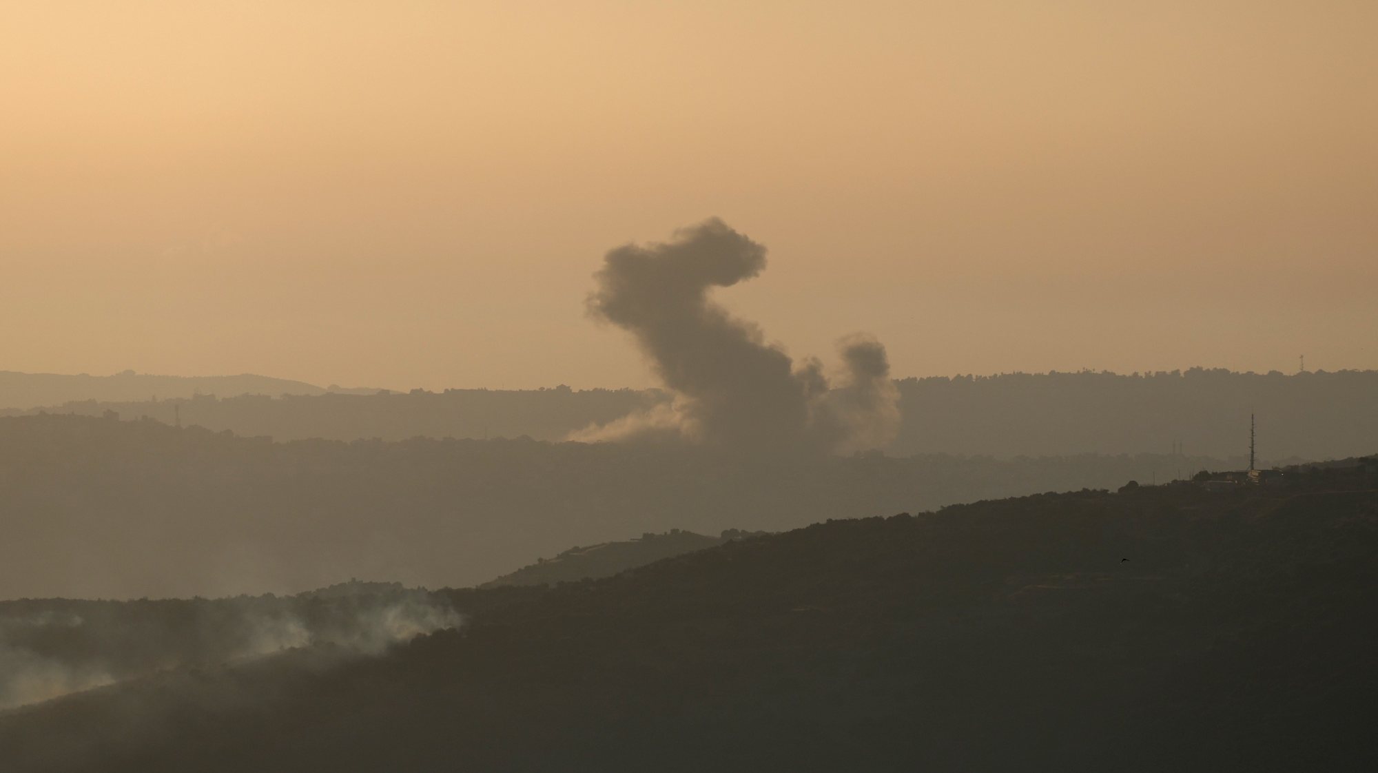 epa11428533 Smoke rises as a result of an Israeli air strike in the southern Lebanese town of Al  Khiam, as seen from northern Israel, 21 June 2024. According to the Israeli army, several rocket launches were identified crossing from Lebanon into northern Israel. No injuries were reported, the Israely army said.  EPA/ATEF SAFADI