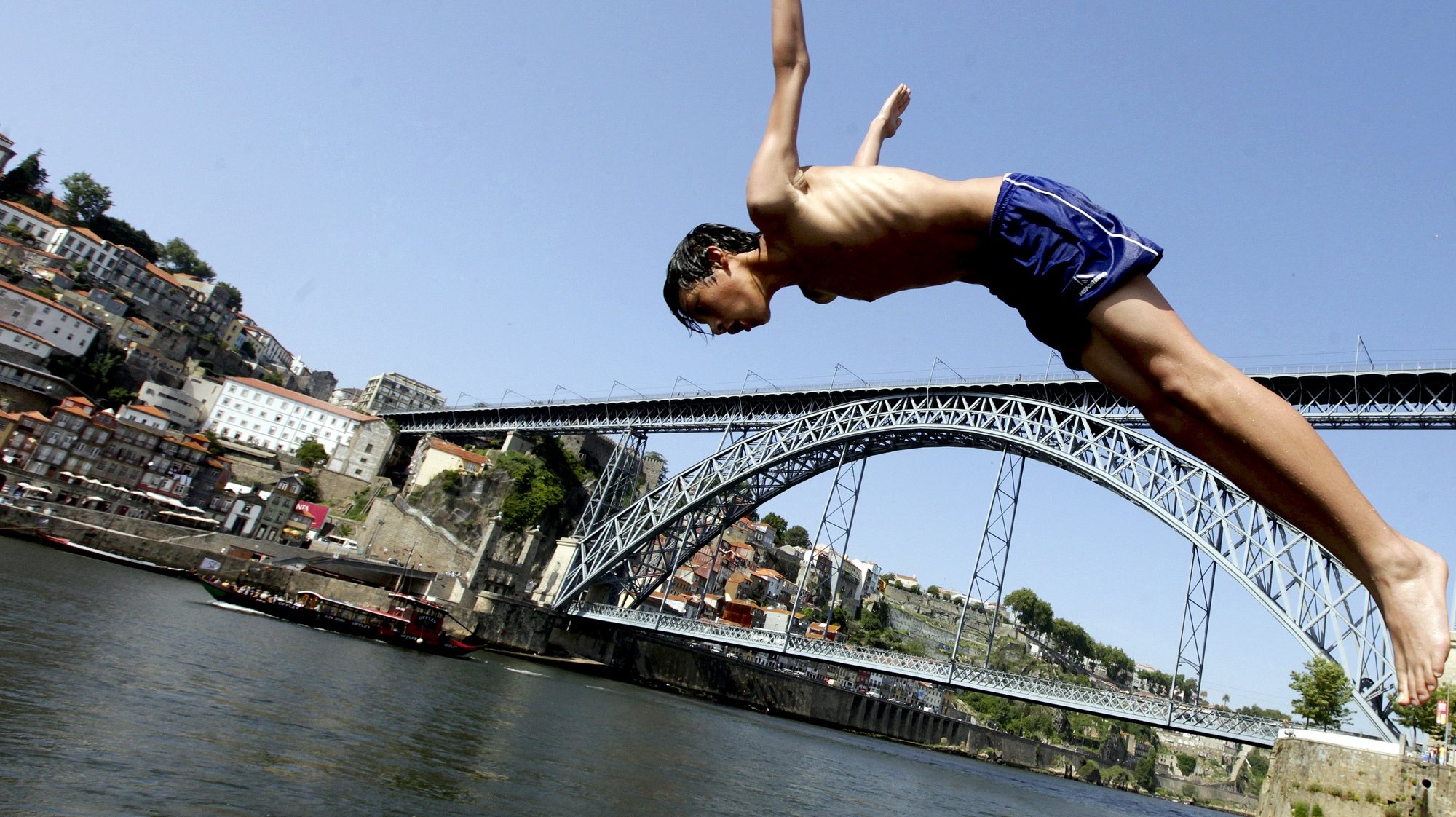 Um rapaz salta para o rio Douro no Porto, 31 de maio de 2012. Temperaturas elevadas na cidade do Porto levaram crianças a tomar banho no rio Douro. JOSE COELHO / LUSA