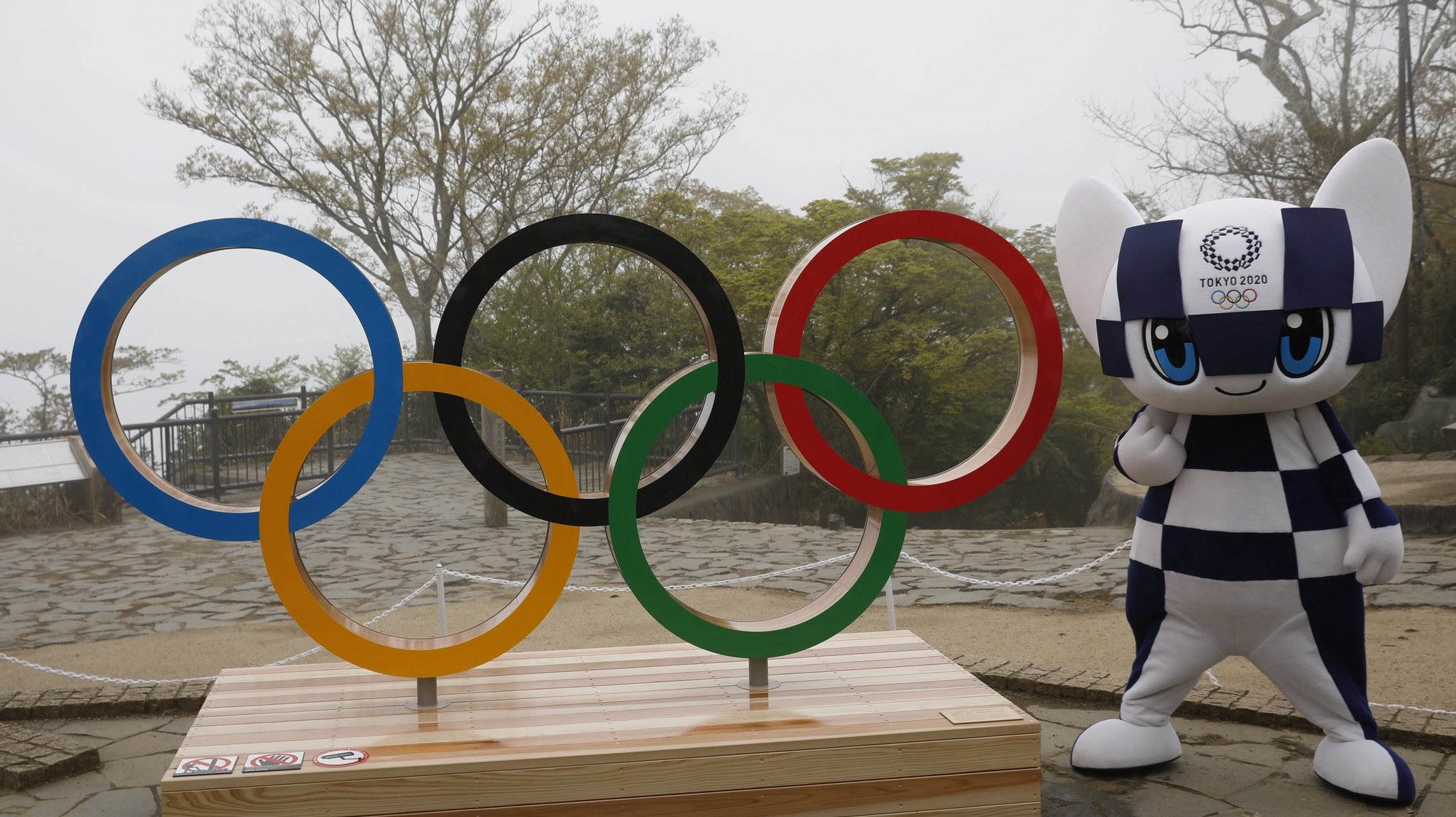 epa09134158 Tokyo 2020 Olympic Games mascot Miraitowa poses with a display of Olympic Symbol after unveiling ceremony of the symbol on Mt. Takao in Hachioji, Japan, 14 April 14, 2021, to mark 100 days before the start of 2020 Tokyo Olympic Games.  EPA/KIM KYUNG-HOON / POOL