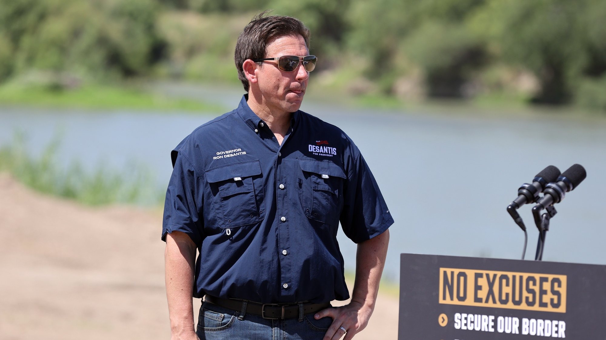 epa10712693 US Republican presidential candidate and Florida Governor Ron DeSantis looks on as Florida Rep. Kiyan Michael (not pictured) speaks during a campaign stop at the border near the Rio Grande river near Eagle Pass,Texas, USA, 26 June 2023.  EPA/Adam Davis