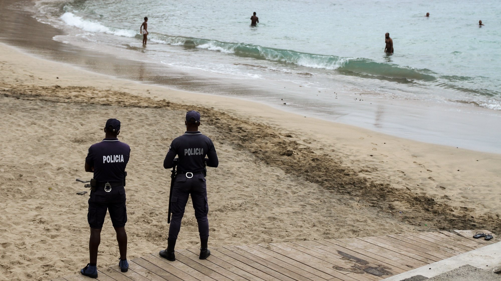 Agentes da polícia controlam os banhistas numa das praias da cidade da Praia, Cabo Verde, 07 de setembro de 2020. As praias da ilha de Santiago reabriram hoje quase seis meses depois das primeiras medidas para evitar a propagação da covid-19, para alegria dos banhistas, que mataram saudades da água do mar na capital de Cabo Verde. FERNANDO DE PINA/LUSA