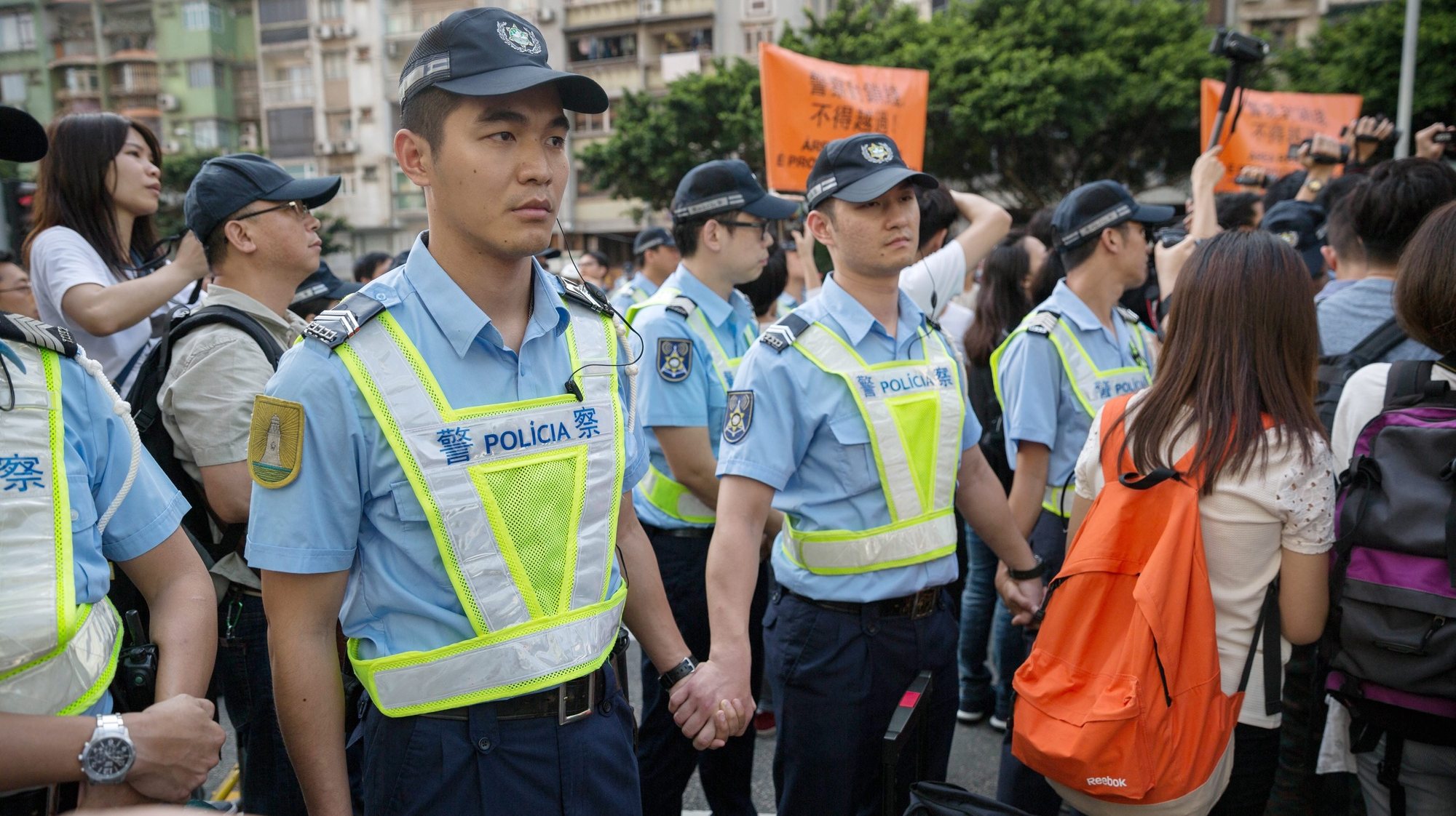 epa05307428 Macau police officers form a line to contain protesters during a march against Macau Chief Executive Fernando Chui Sai On&#039;s decision to donate public money to a Chinese university during a rally in Macau, China, 15 May 2016. Protesters urged the government to rescind its 100 million yuan, 13.5 million euros, donation from the Macao Foundation, a government organisation, to Jinan University in China. Chui is the president of the trustees&#039; council of Macao Foundation and he has also been a vice-chairman of the board of Jinan University since 2010.  EPA/JEROME FAVRE