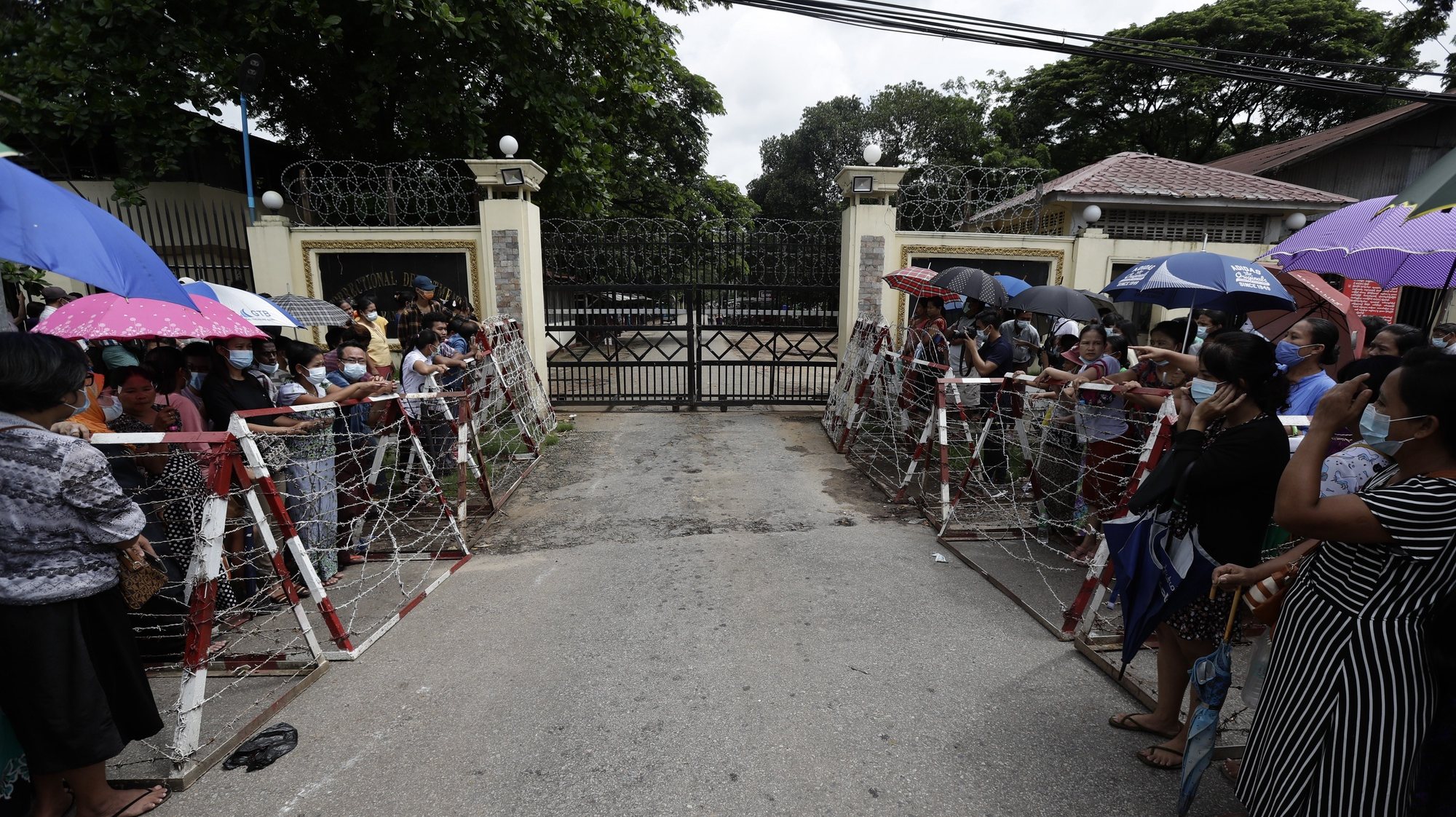 epa09312589 People wait behind barricades for their relatives to be released outside the main entrance of Insein prison compound in Yangon, Myanmar, 30 June 2021. The prison authority confirmed the upcoming release of about 700 prisoners from Yangon&#039;s Insein jail, including some who were jailed for opposing the military. According to the Assistance Association for Political Prisoners (Burma) - AAPPB, as of June 2021 a total of 5,224 people who are against the February 2021 coup are being held in detention centers across Myanmar.  EPA/STR
