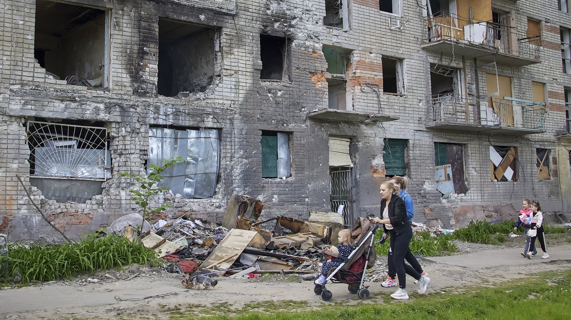 epa09974740 Locals walk past a building that was damaged during shelling in the outskirts of Kharkiv, Ukraine, 25 May 2022. Ukraine&#039;s second-largest city Kharkiv and its surroundings witnessed repeated airstrikes from Russian forces. On 24 February, Russian troops invaded Ukrainian territory starting a conflict that has provoked destruction and a humanitarian crisis. According to the UNHCR, more than 6.5 million refugees have fled Ukraine, and a further 7.7 million people have been displaced internally within Ukraine since.  EPA/SERGEY KOZLOV