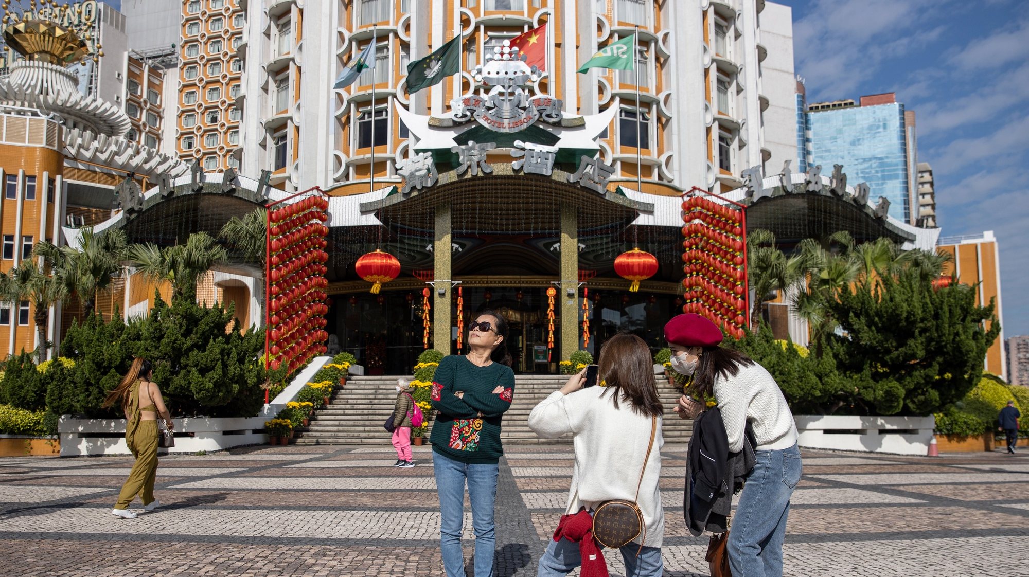 epaselect epa10422325 Mainland Chinese tourists take photos outside the Lisboa Casino in Macau, China, 22 January 2023. Macau borders reopened earlier this month and the city has launched a promotional campaign to boost tourism, offering Hong Kong residents a &#039;half-price&#039; round-trip if travellers spend a night there during the Chinese Lunar New Year period. The  Chinese lunar new year, also called &#039;Spring Festival&#039;, falls on 22 January 2023, marking the beginning of the Year of the Rabbit.  EPA/JEROME FAVRE