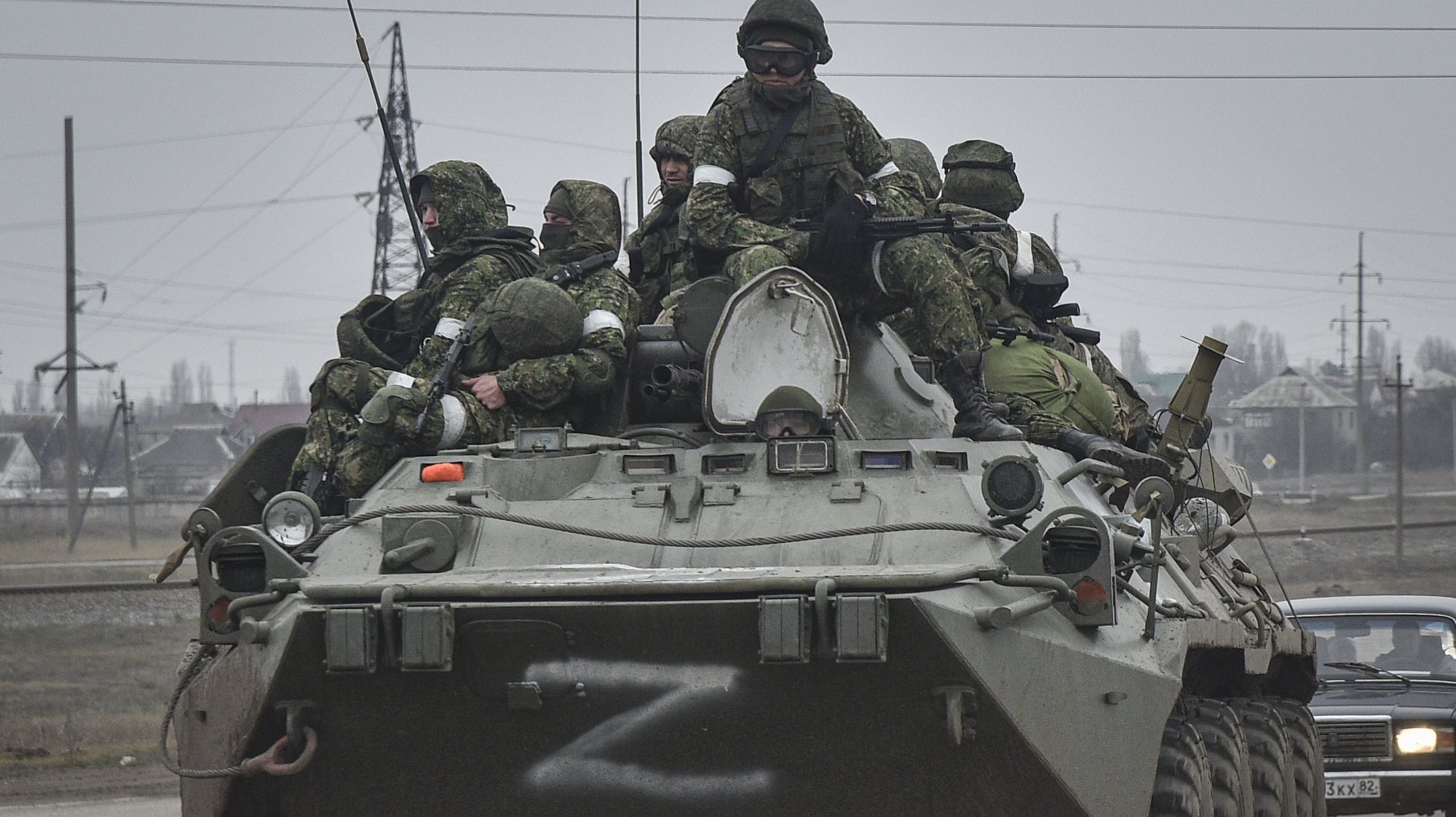 epa09784383 Russian soldiers on the armoured personnel carrier BTR-80 move towards mainland Ukraine on the road near Armiansk, Crimea, 25 February 2022. Russian troops entered Ukraine on 24 February prompting the country&#039;s president to declare martial law and triggering a series of announcements by Western countries to impose severe economic sanctions on Russia.  EPA/STRINGER