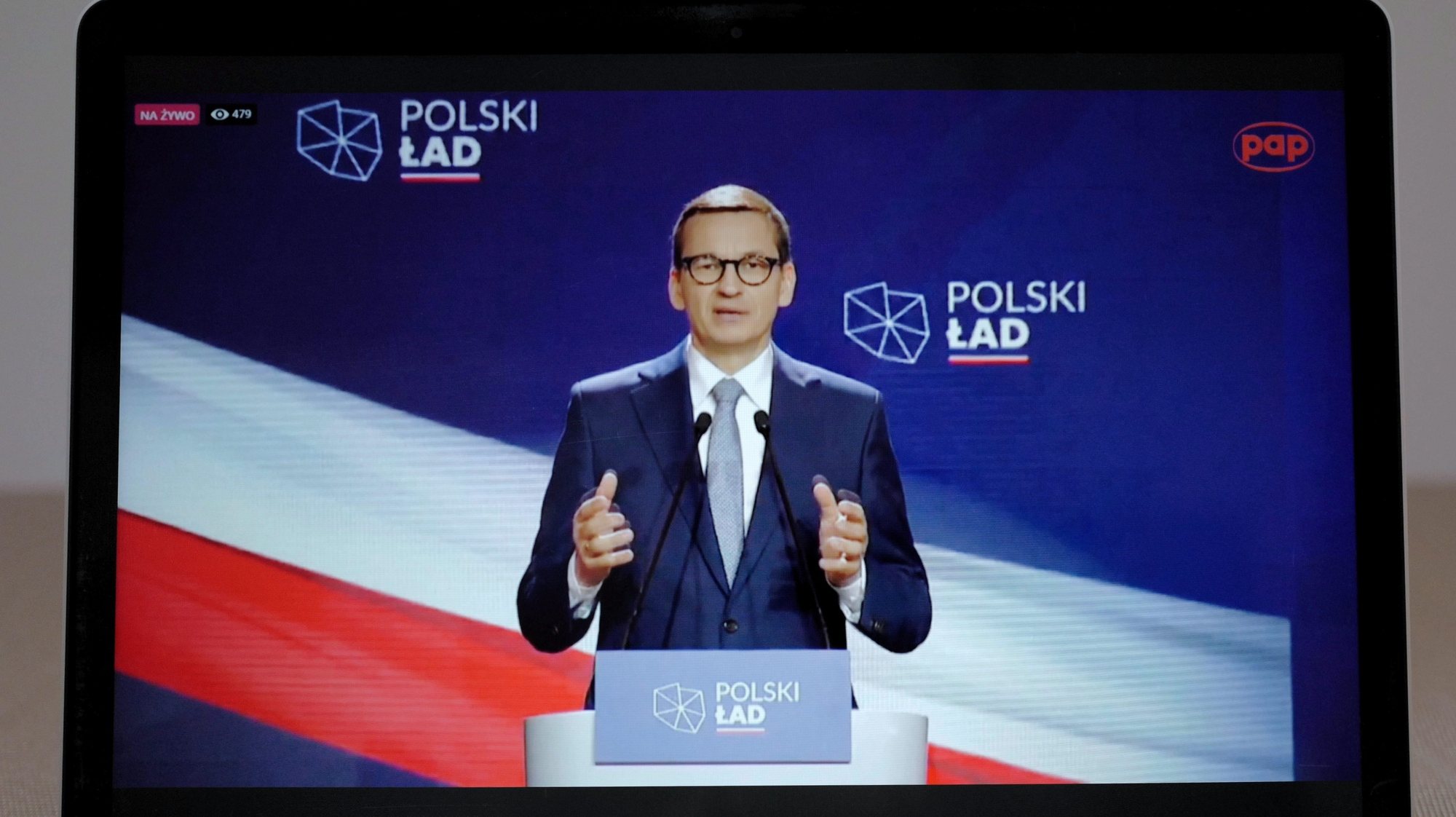 epa09242809 Polish Prime Minister Mateusz Morawiecki presents 10 key points of the government&#039;s Polish New Deal plan to revive the national economy after the Covid-19 pandemic during a speech watched on a screen in Warsaw, Poland, 02 June 2021. The plan, which envisages major investment in public infrastructure along with overhauls of the tax and healthcare systems, was made public last month but Mateusz Morawiecki added more details during a presentation on 02 June 2021.  EPA/Mateusz Marek POLAND OUT