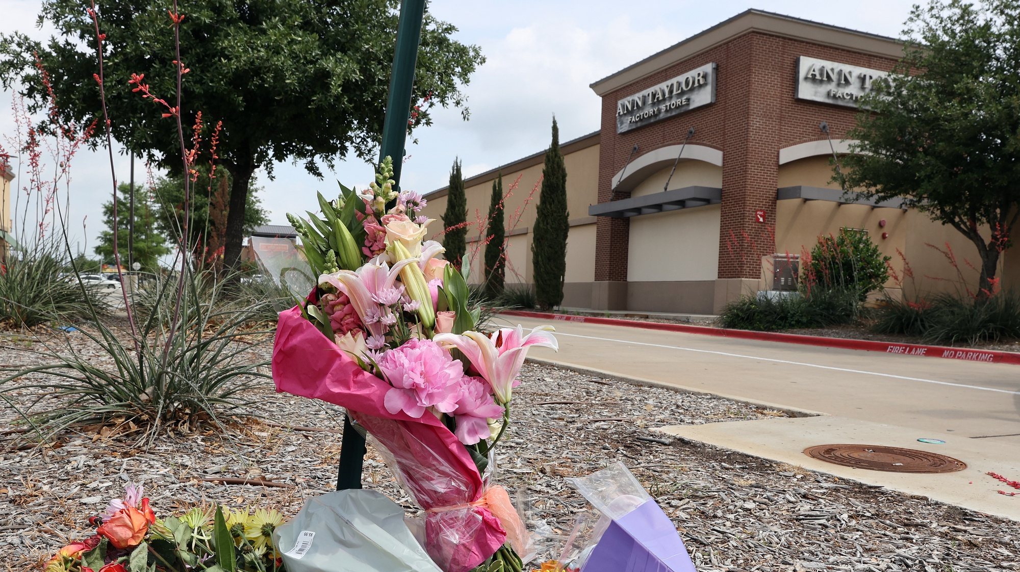 epa10614292 A boquet of flowers is left in front of the Allen Premium Outlet Mall entrance in remembrance of those killed during the mass shooting that happened the day before in Allen, Texas, USA, 07 May 2023.  According to the police, nine people including the gunman were killed on 06 May 2023 after a man opened fire at passers-by.  EPA/ADAM DAVIS