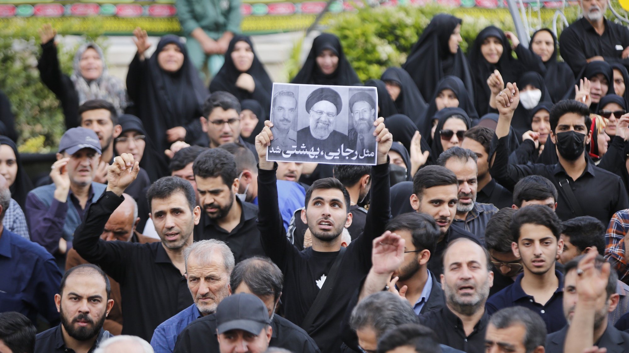 epa11356079 An Iranian man holds up a poster of Iranian president Ebrahim Raisi during a mourning ceremony in Tehran, Iran, 20 May 2024. Iranian President Raisi, Foreign Minister Amir-Abdollahian and several others were killed in a helicopter crash on 19 May 2024, after an official visit in Iran&#039;s northwest near the border with Azerbaijan, the Iranian government confirmed. Iran announced a five-day public mourning.  EPA/ABEDIN TAHERKENAREH