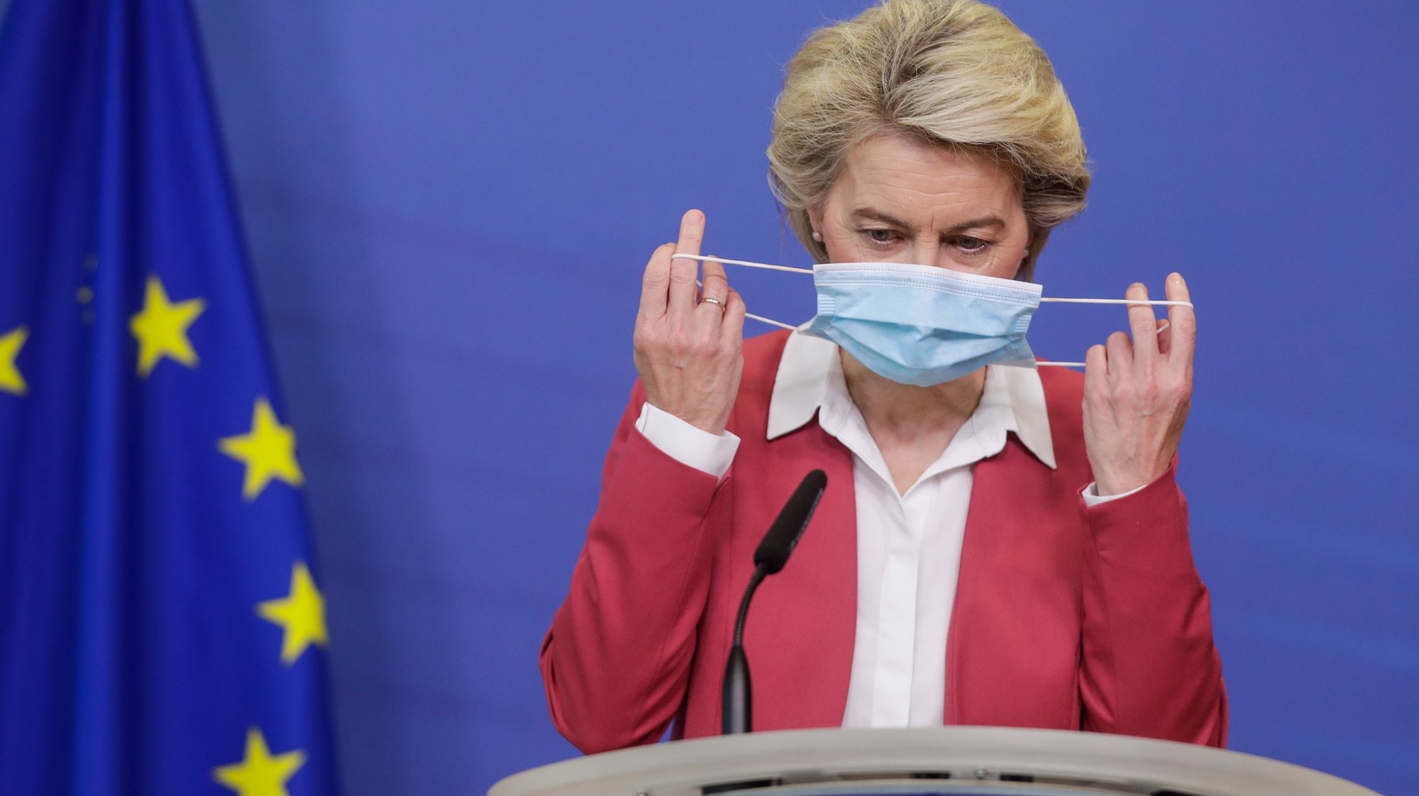 epa09369476 European Commission President Ursula von der Leyen removes her protective face mask as she gives a statement on a new milestone in the EU Vaccines Strategy, at the European Commission, in Brussels, Belgium, 27 July 2021. She stated that the EU Commission&#039;s target to protect 70 percent of adults in the European Union with at least one vaccination in July, was achieved on 27 July 2021 and that 57 percent of adults already have the full protection of double vaccination.  EPA/STEPHANIE LECOCQ / POOL