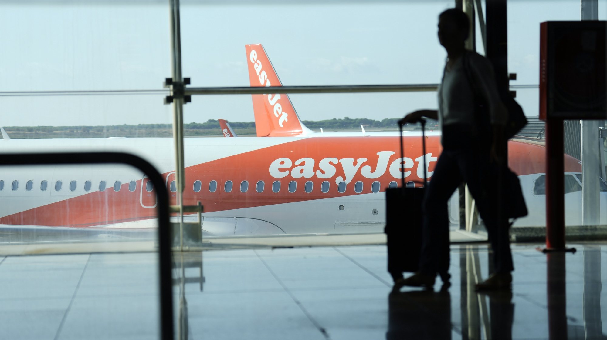 epa10116908 A man walks past an EasyJet plane at El Prat airport, Barcelona, Spain, 12 August 2022. The first day of the EasyJet pilots&#039; strike in August has caused cancellations at El Prat and in Palma de Mallorca Airports.  EPA/ALEJANDRO GARCIA