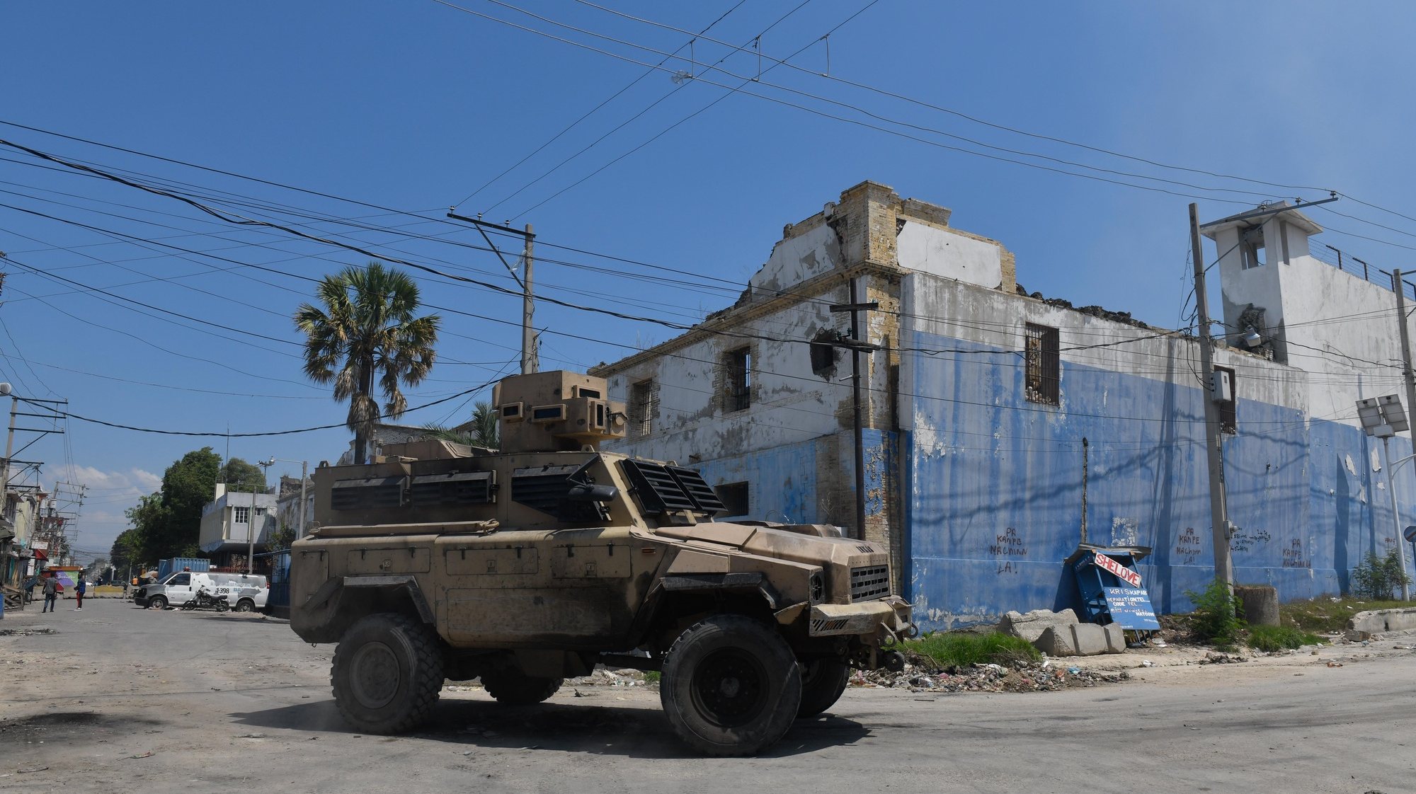 epa11220483 A military vehicle drives past the National Penitentiary after a fire broke out, in Port-au-Prince, Haiti, 14 March 2024. The penitentiary was attacked by armed gangs on 02 March, causing a prison break of around 3,000 inmates, including gang members and leaders. According to a statement by the Caribbean Community and Common Market (CARICOM) regional bloc on 11 March, Haiti&#039;s Prime Minister Ariel Henry announced his government would resign after the establishment of a transitional presidential council and the appointment of a new interim prime minister. Henry&#039;s resignation comes following weeks of crisis and gang violence in the country.  EPA/Johnson Sabin