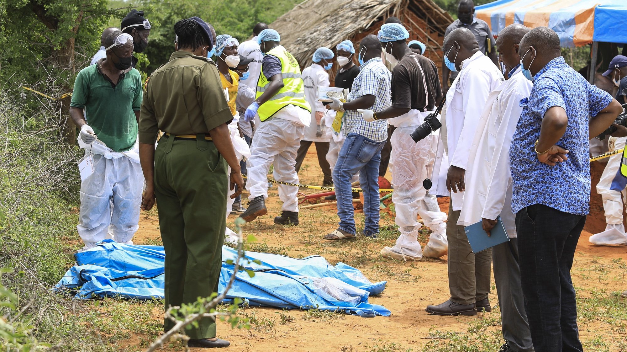 epa10588064 Kenyan homicide detectives and forensic experts from the Directorate of Criminal Investigations (DCI), examine exhumed bodies from several shallow mass graves of suspected members of a Christian cult after starving themselves to death, after allegedly being told by their controversial preacher Paul Mackenzie that they would go to heaven if they starved themselves to death, in the coastal Shakahola forest, in Kilifi, Kenya, 23 April 2023. According to the Police, 18 more bodies were exhumed on 23 April bringing the tally of bodies recovered to at 39.  EPA/STR