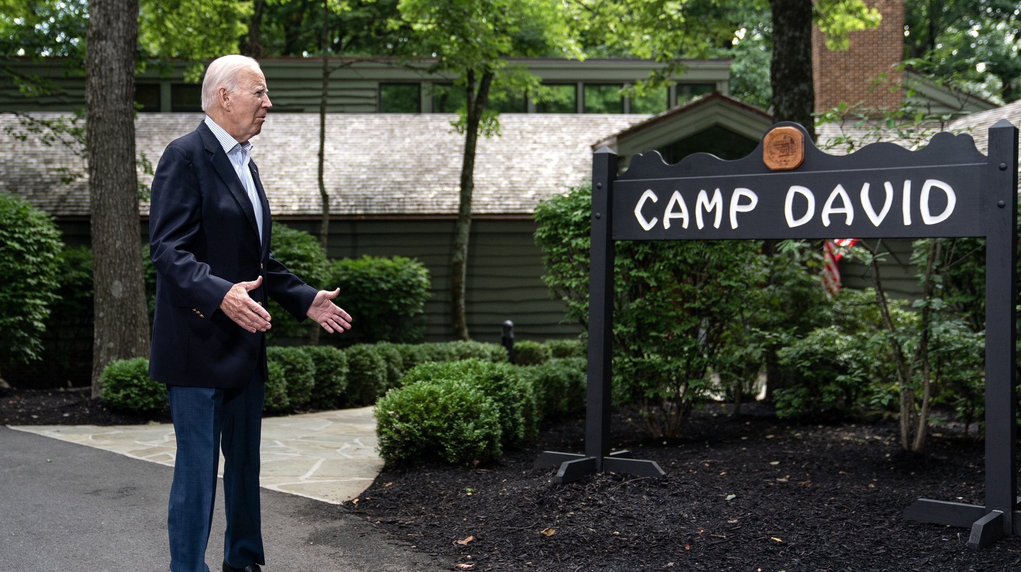 epa10805869 US President Joe Biden gestures as he stands beside the Camp David sign during a trilateral summit at Camp David in Frederick County, Maryland, USA, 18 August 2023. US President Biden is hosting a trilateral summit with South Korean President Yoon Suk Yeol and Japanese Prime Minister Fumio Kishida at the Camp David presidential retreat.  EPA/NATHAN HOWARD / POOL