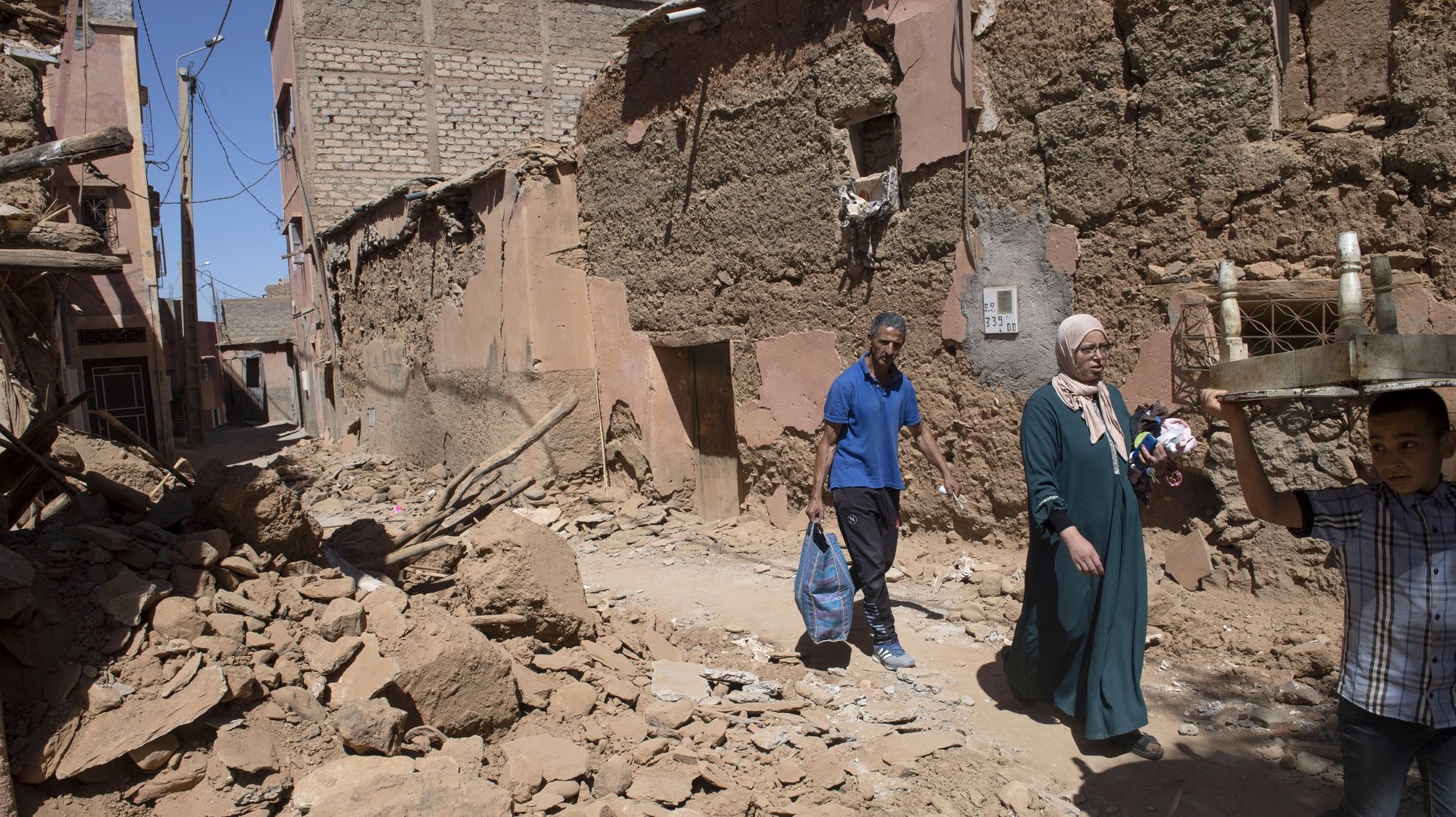 epa10852575 Members of a family walk past damaged buildings in Amizmiz, south of Marrakesh, Morocco, 10 September 2023, following a powerful earthquake. A magnitude 6.8 earthquake that struck central Morocco late 08 September has killed at least 2,012 people and injured 2,059 others, 1,404 of whom are in serious condition, damaging buildings from villages and towns in the Atlas Mountains to Marrakesh, according to a report released by the country&#039;s Interior Ministry. The earthquake has affected more than 300,000 people in Marrakesh and its outskirts, the UN Office for the Coordination of Humanitarian Affairs (OCHA) said. Morocco&#039;s King Mohammed VI on 09 September declared a three-day national mourning for the victims of the earthquake.  EPA/JALAL MORCHIDI