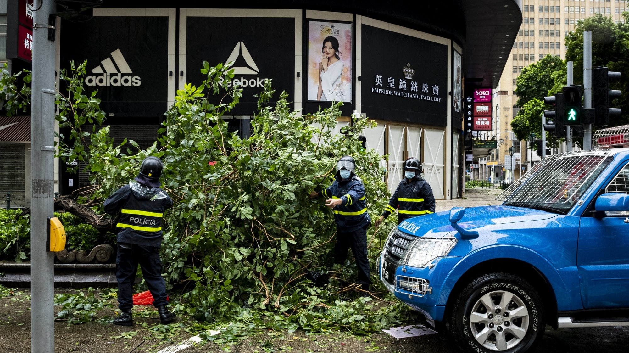 epa08612362 City workers remove an uprooted tree after Tropical storm Higos had passed very close to Macao, China, 19 August 2020. Higos is now 100 kilometers northwest of Macau and &#039;is gradually moving away&#039; from the territory.  EPA/TATIANA LAGES