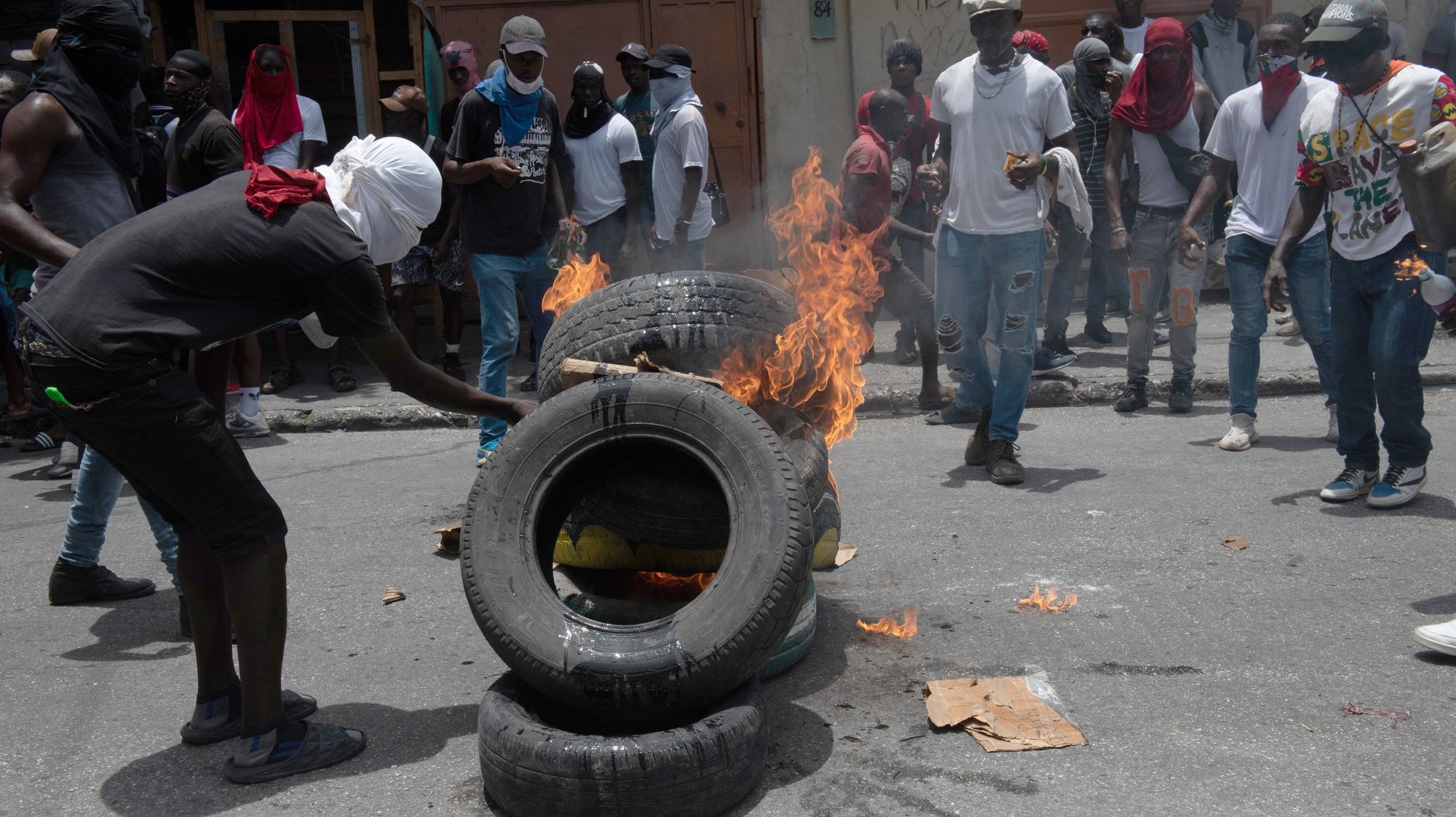 epa10800646 People set tires on fire during a demonstration in the middle of a street in Port-au-Prince, Haiti, 14 August 2023. Haitian National Police officers dispersed the demonstrators with tear gas after residents of the Carrefour-Feuilles area protested against the insecurity they suffer due to the action of armed gangs.  EPA/Johnson Sabin