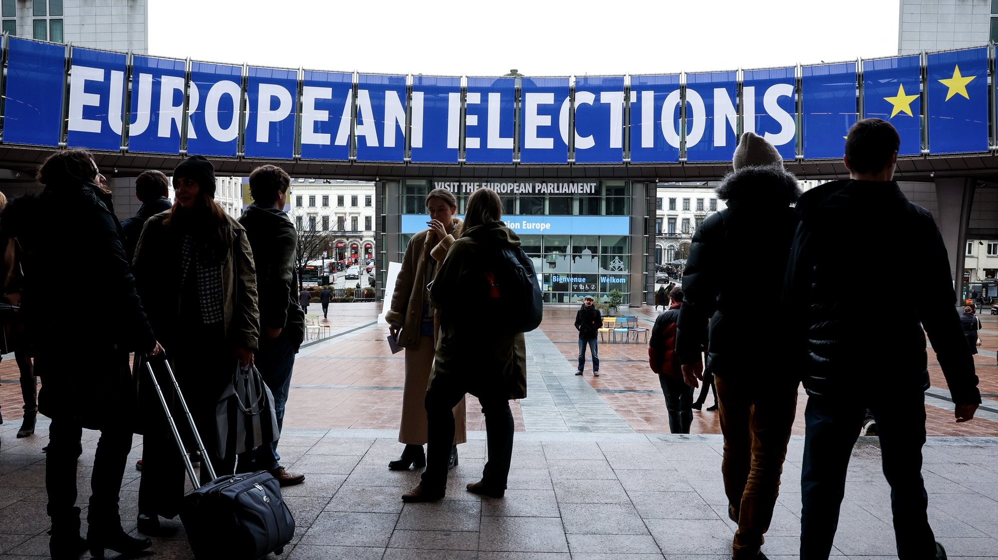 epa11172242 Pedestrians stand next to banners for the 2024 European election displayed in front of the European Parliament building, in Brussels, Belgium, 22 February 2024. The European elections are scheduled to be held from 06 to 9 June 2024.  EPA/OLIVIER HOSLET