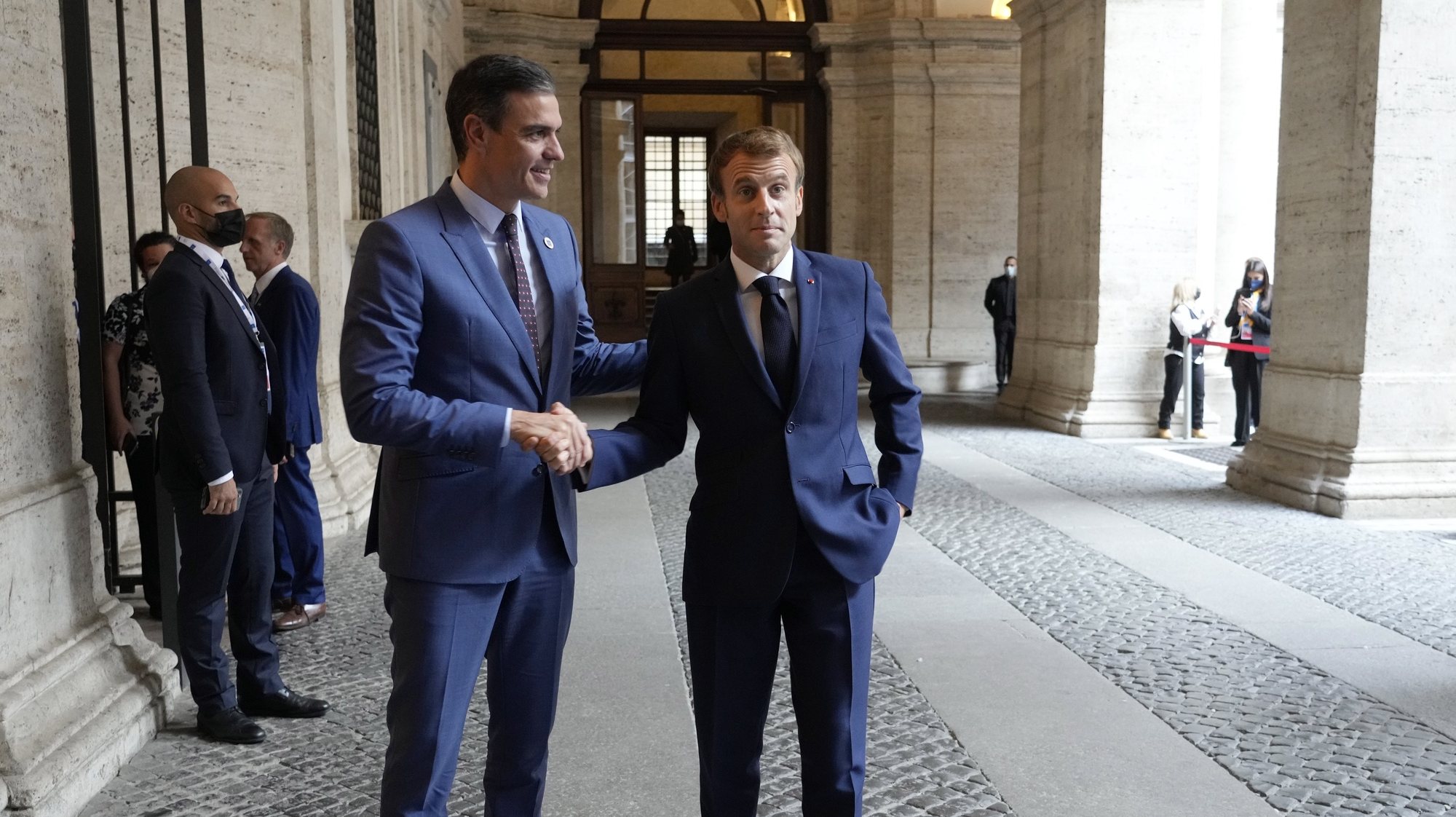 O Presidente francês Macron à direita cumprimenta o primeiro-ministro espanhol Pedro Sanchez