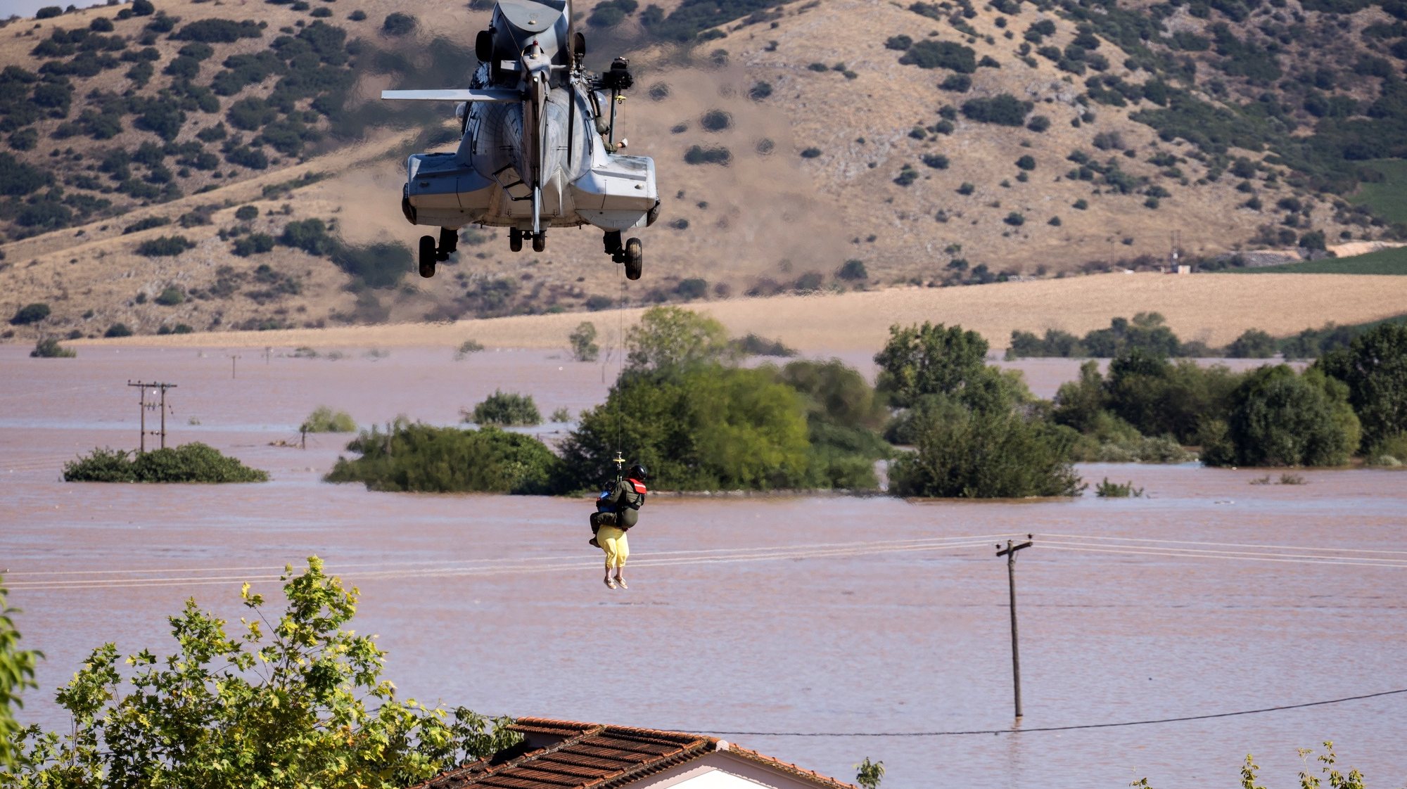 epa10848625 A helicopter and its crew work on rescuing people stranded in a flooded area after Storm Daniel, in Piniada village, near Trikala, Thessaly, Greece, 08 September 2023. At least six people died and another six still missing in a flooded central Greek region as unprecedented bad weather conditions struck the country.  EPA/ACHILLEAS CHIRAS