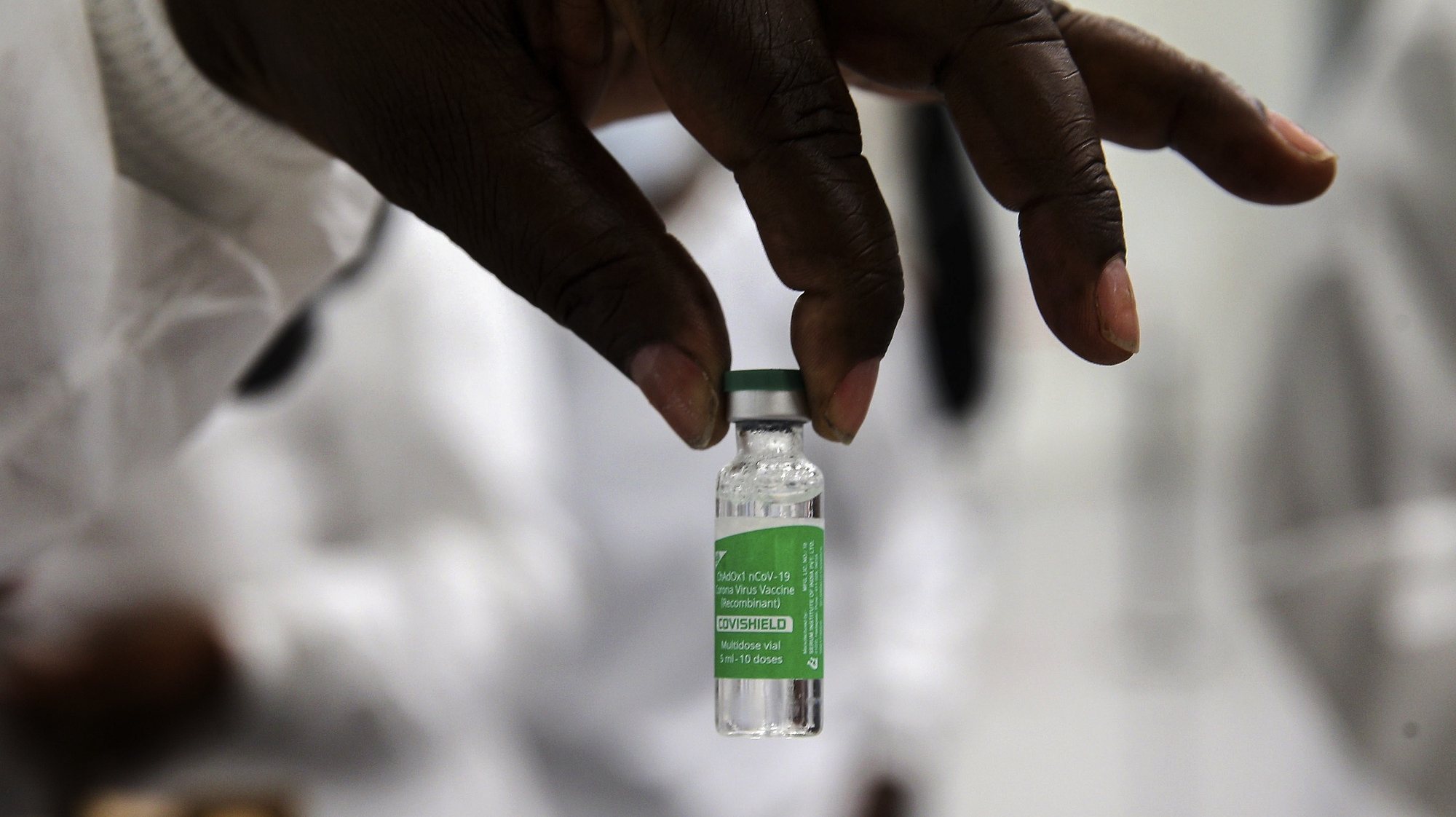 Um profissional de saúde mostra uma vacina durante a inauguração do depósito central de vacinas de Angola, no dia em que chegaram ao país as primeiras 624.000 doses de vacinas contra a covid-19, no aeroporto Internacional 4 de Fevereiro, que contou com a presença da ministra da Saúde, Silvia Lutucuta (ausente da foto), no âmbito da iniciativa Covax, Luanda, Angola, 2 de março de 2021. AMPE ROGÉRIO/LUSA