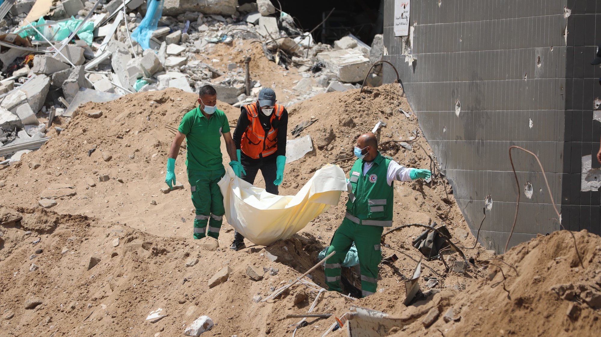 epaselect epa11265684 Crew members from the Palestinian ministries of health, justice, and interior recover a body from under the rubble after the Israeli army had left the Al-Shifa Medical Hospital Complex in Gaza City, 08 April 2024. According to the Israeli army spokesperson, approximately 500 suspects affiliated with Hamas were apprehended and 200 were eliminated. More than 33,000 Palestinians and over 1,450 Israelis have been killed, according to the Palestinian Health Ministry and the Israel Defense Forces (IDF), since Hamas militants launched an attack against Israel from the Gaza Strip on 07 October 2023, and the Israeli operations in Gaza and the West Bank which followed it.  EPA/MOHAMED HAJJAR