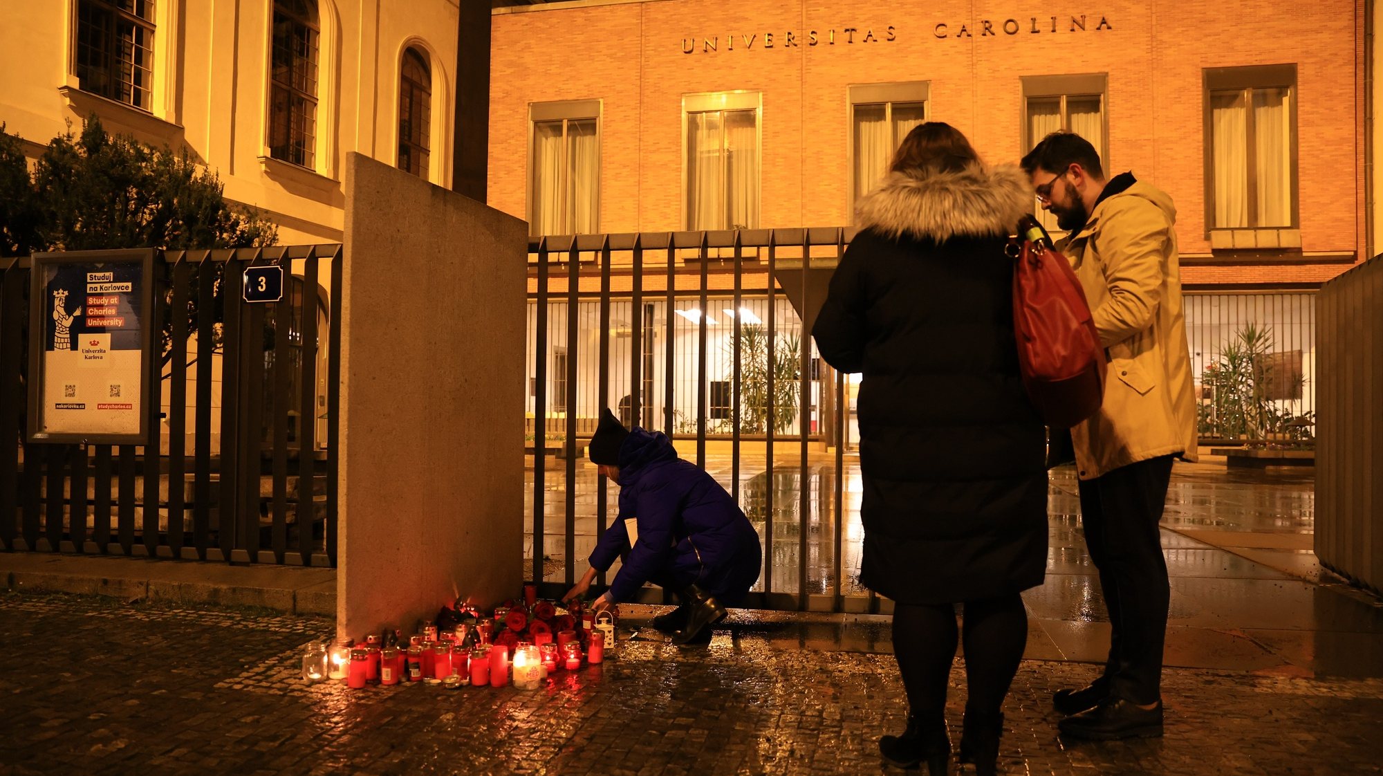 epa11040315 People place candles near the scene of a shooting at Charles University in central Prague, 21 December 2023. According to the Police President, Martin Vondrasek, there are more than 15 people dead and 24 injured, but that these may not be final numbers. According to Czech police the perpetrator of  was a 24 year-old Charles University student.  EPA/MARTIN DIVISEK