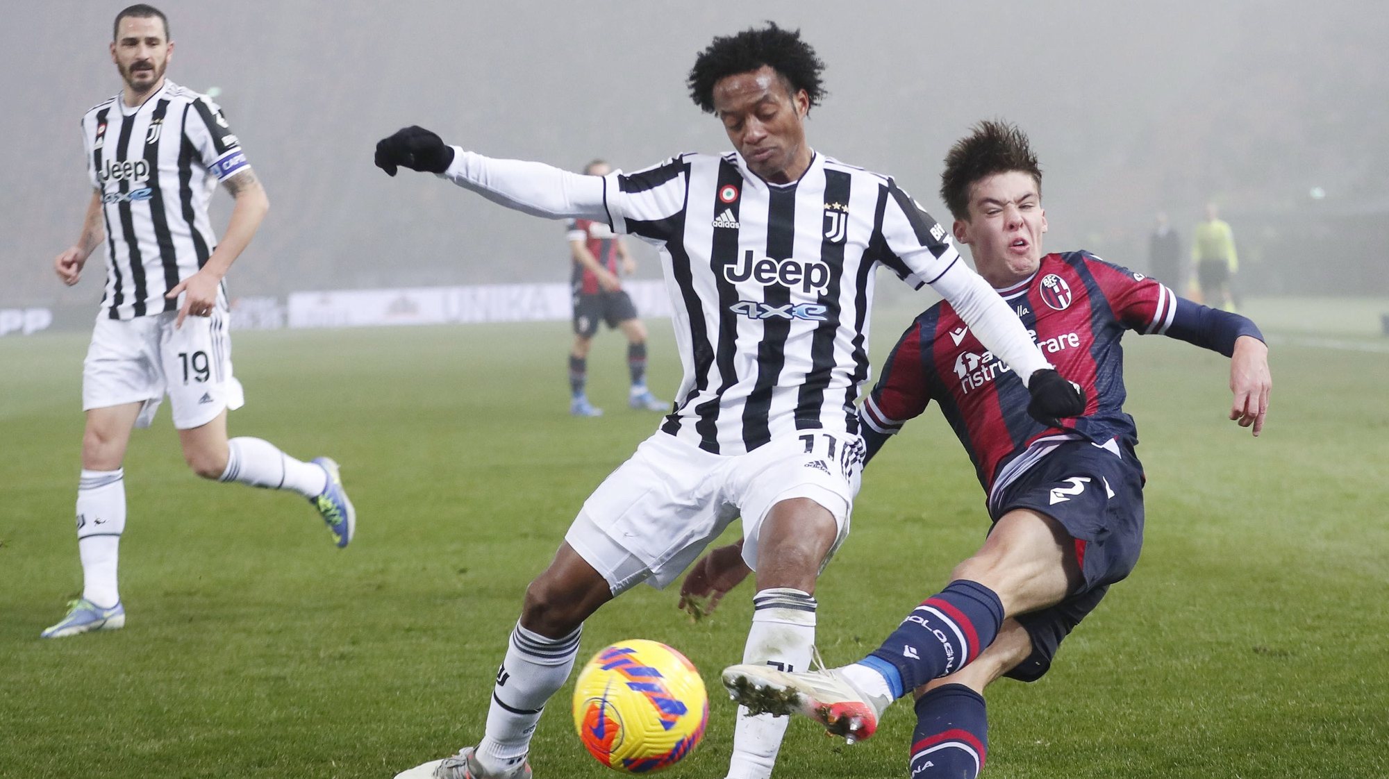 epa09648847 Bologna&#039;s Aaron Hickey (R) and Juventus&#039; Juan Cuadrado (C) in action during the Italian Serie A soccer match between Bologna FC and Juventus FC in Bologna, Italy, 18 December 2021.  EPA/SERENA CAMPANINI