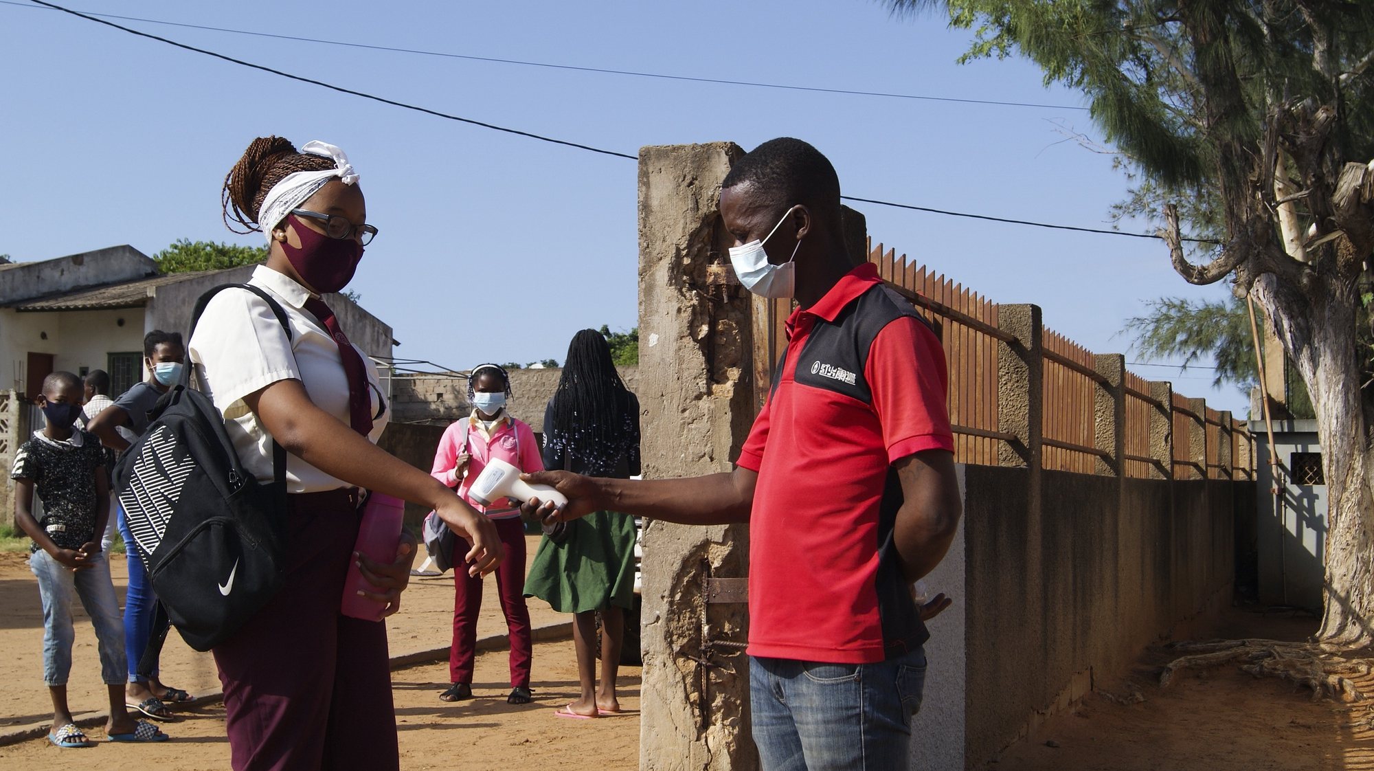 A student measures her body temperature at the entrance of a school on the first day back to school due to covid-19, in Maputo, Mozambique, 22 March 2021. Mozambique lived in a state of emergency between April and September 2020, and since then the state of calamity has been in effect, a legal designation to frame several restrictions aimed at preventing covid-19, which included the suspension of classes. LUISA NHANTUMBO/LUSA