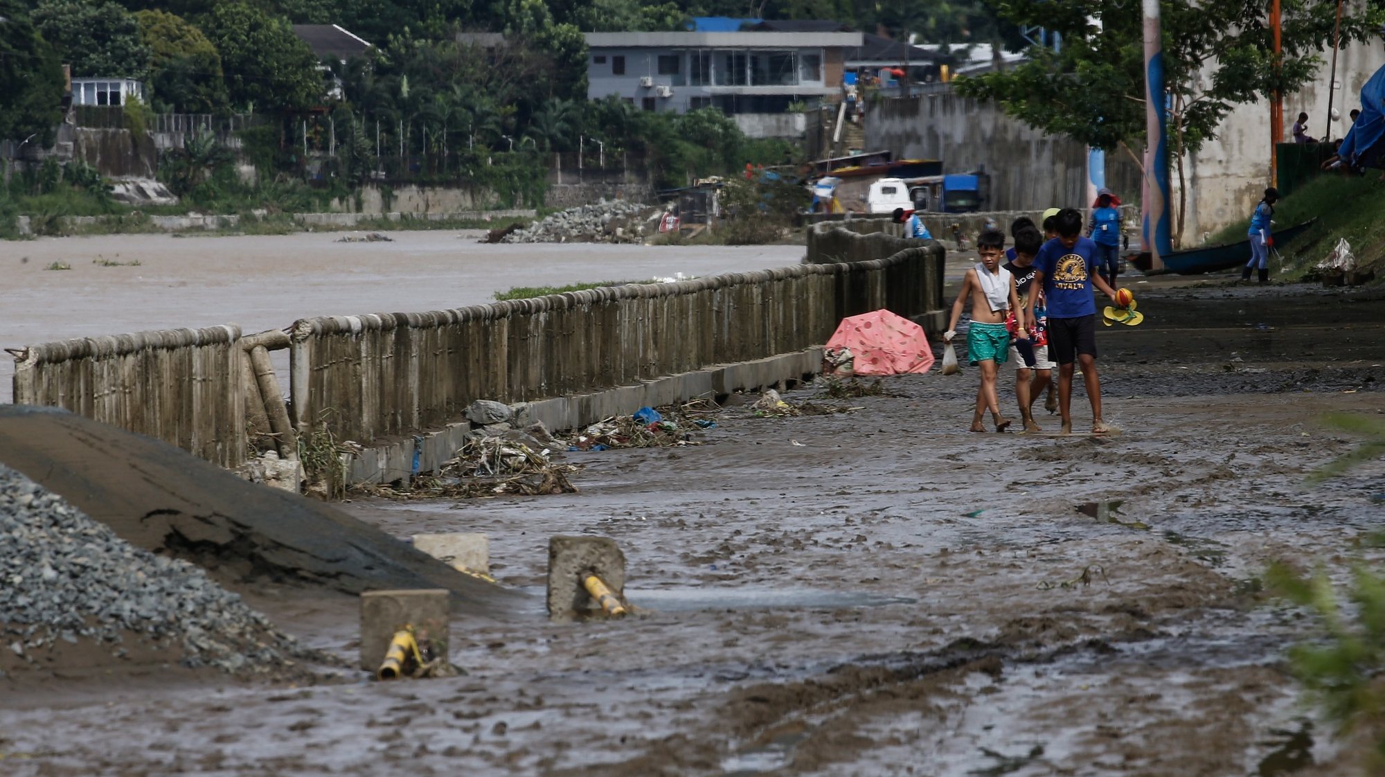 epa10274706 Children walk along a muddied path a day after rains caused by Typhoon Nalgae flooded a riverside park in Marikina City, Metro Manila, Philippines 30 October 2022. Heavy rains brought by Typhoon Nalgae killed 45 people and injured a dozen as it crossed various provinces of the Philippines, according to the National Disaster Risk Reduction and Management Council (NDRRMC).  EPA/ROLEX DELA PENA