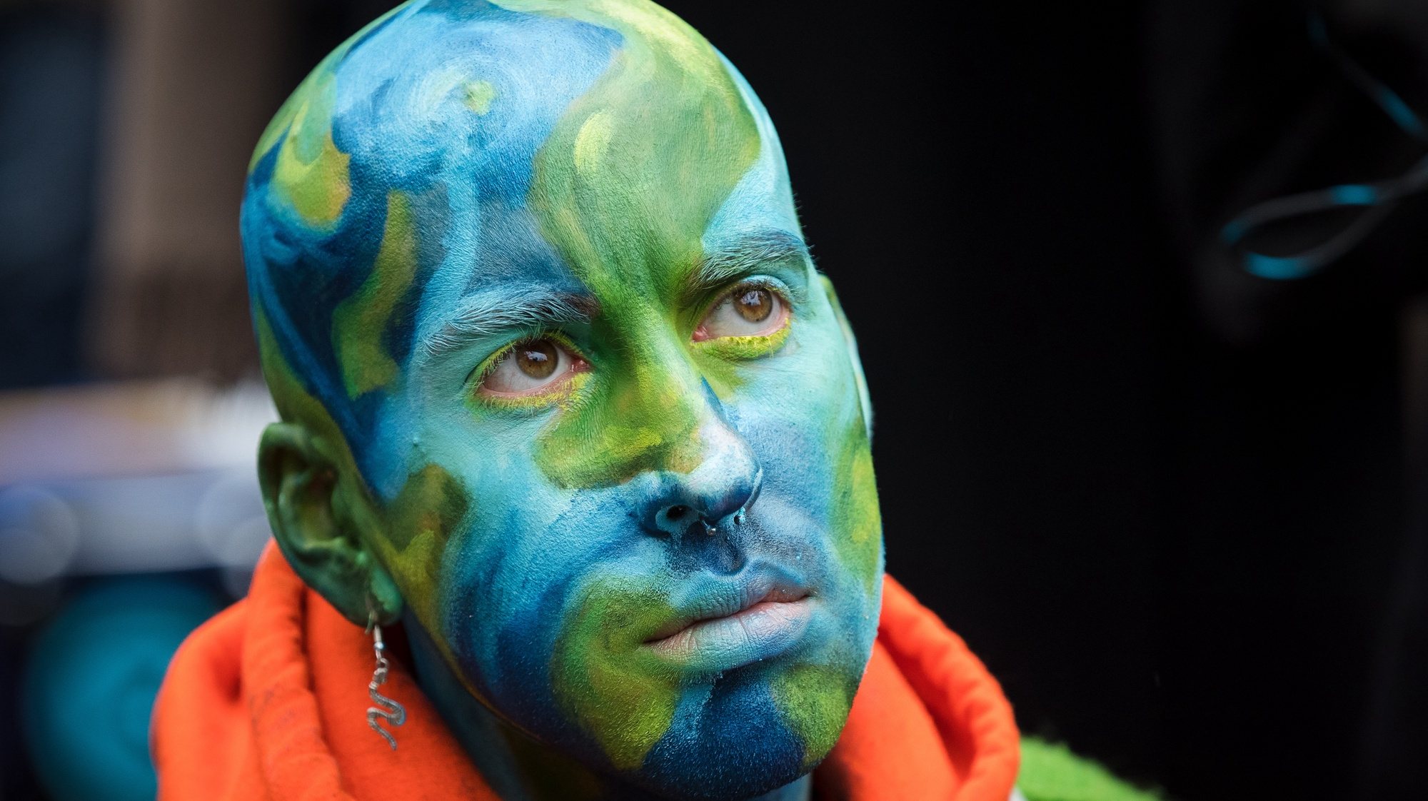epa07904194 An Extinction Rebellion protester with his head painted in the colors of planet Earth sits in the road in Trafalgar Square during a rally in London, Britain, 07 October 2019. The global environmental movement Extinction Rebellion announced worldwide  climate change protests and blockades starting 07 October.  EPA/VICKIE FLORES
