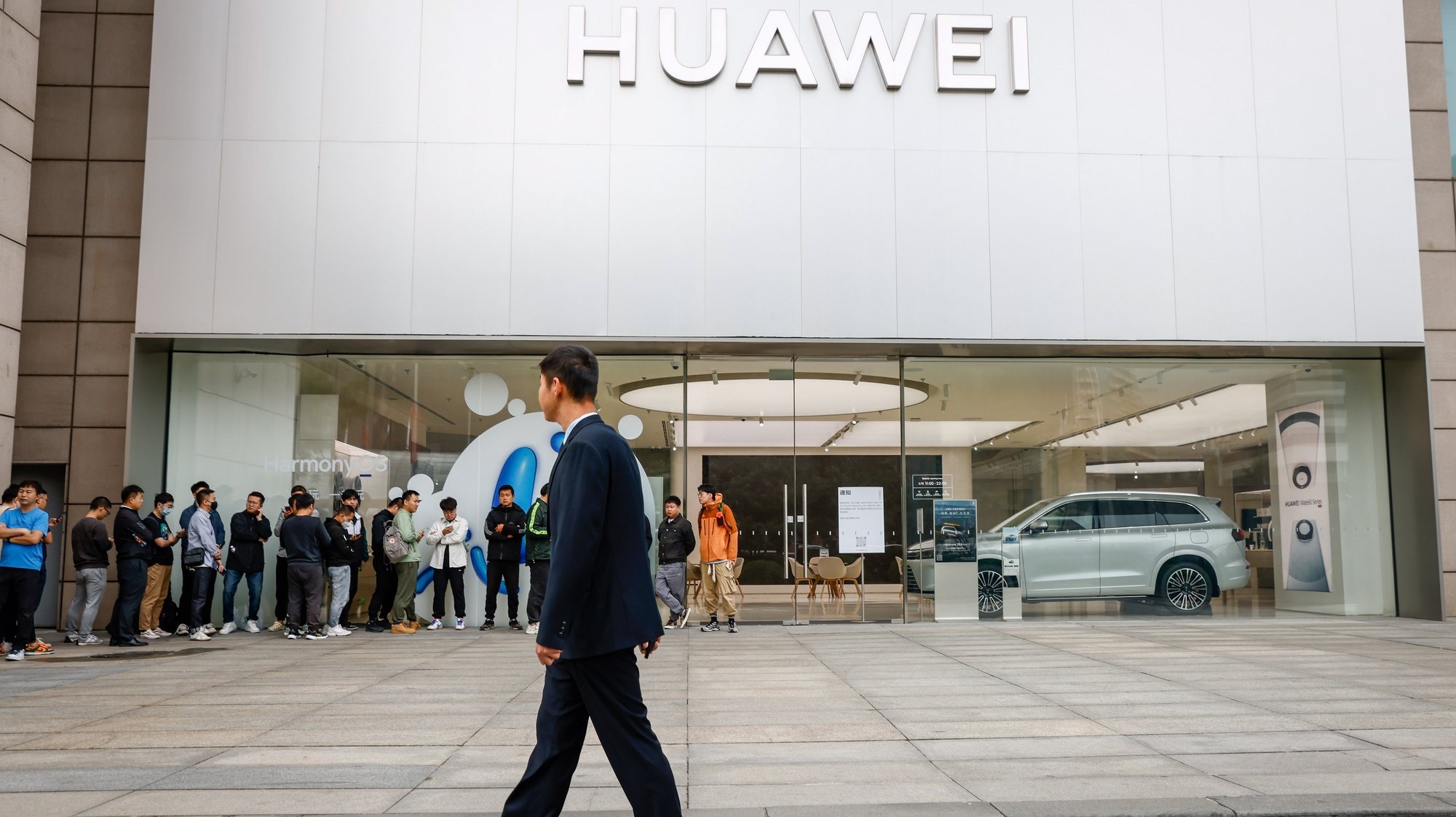 epa10881888 A security person patrols as people lineup outside a Huawei store in Beijing, China, 25 September 2023. Huawei launched its new line of Mate 60 models which are the Mate 60, Mate 60 Pro, Mate 60 Pro+ and Mate 60 Ultimate Design.  EPA/MARK R. CRISTINO
