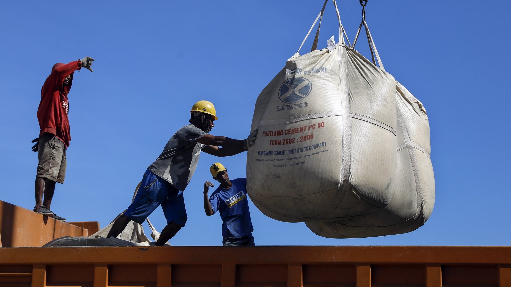 epa10105179 Labourers unload sacks of cement from a cargo ship onto a truck at a port in Dili, East Timor, also known as Timor Leste, 04 August 2022. According to Asian Development Bank (ADP) Timor Leste&#039;s gross domestic product (GDP) expected to grow 2.5 percent in 2022 and 3.1 percent in 2023.  EPA/ANTONIO DASIPARU
