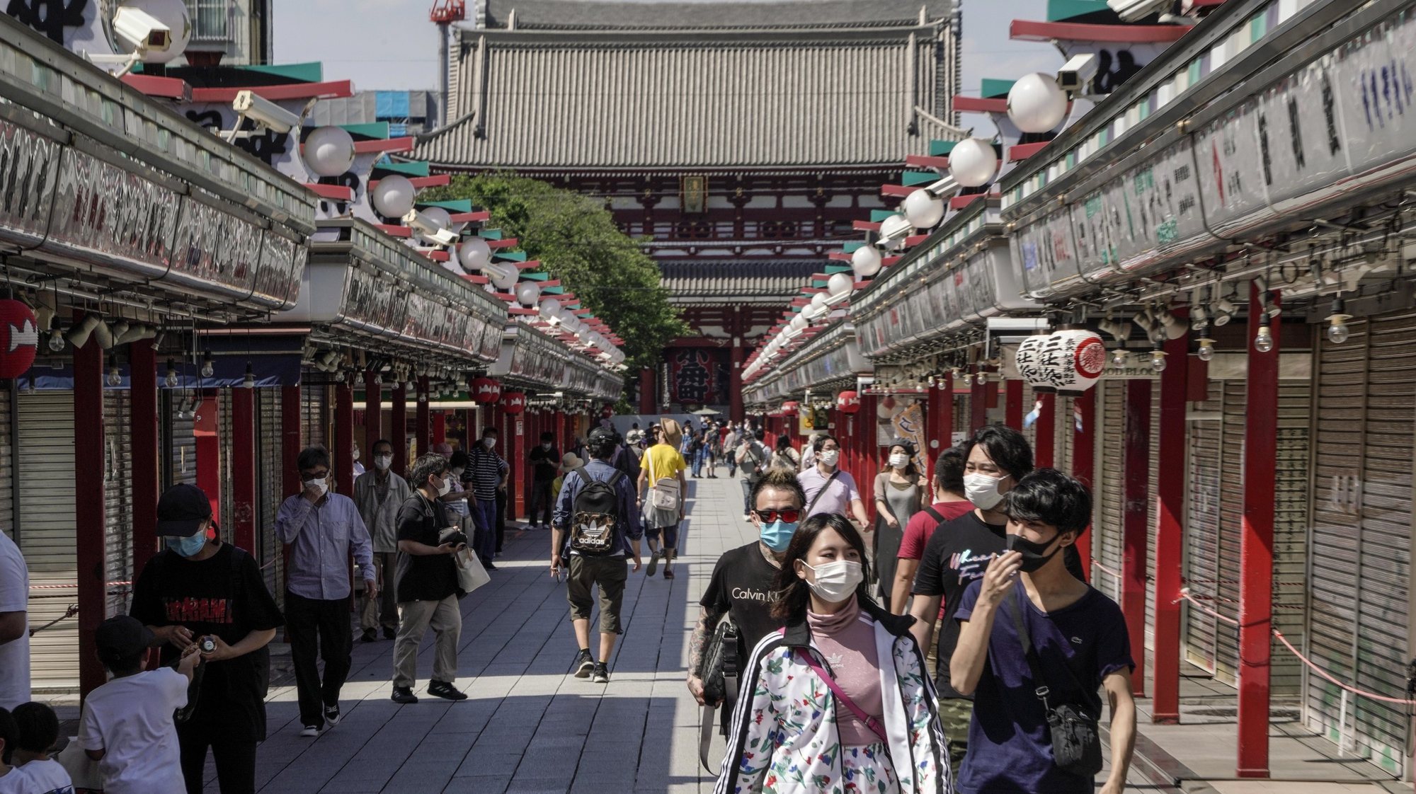 epa08427427 People walk through Nakamise Street, the main approach to Sensoji temple (Rear) at Asakusa, a sightseeing spot in Tokyo, Japan, 17 May 2020 under a coronavirus state of emergency. Japanese Prime Minister Shinzo Abe announced on 14 May 2020 to lift the state of emergency from 39 of 47 prefectures in Japan and is expected he may re-determine 0n 21 May to lift the declaration of coronavirus state emergency from all over the country including Tokyo and the capital area, and Osaka, second biggest city in Japan.  EPA/KIMIMASA MAYAMA