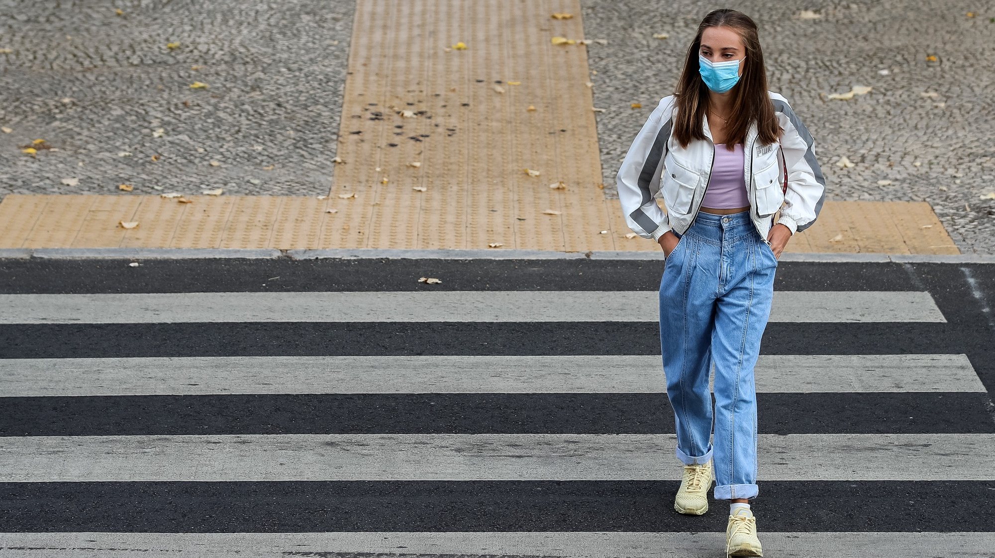 Uma aluna usando uma máscara de proteção respiratória à chegada à Escola Secundária José Falcão, no dia que assinala o regresso às aulas, com as regras no contexto de pandemia da Covid-19, em Coimbra, 17 de setembro de 2020. PAULO NOVAIS/LUSA