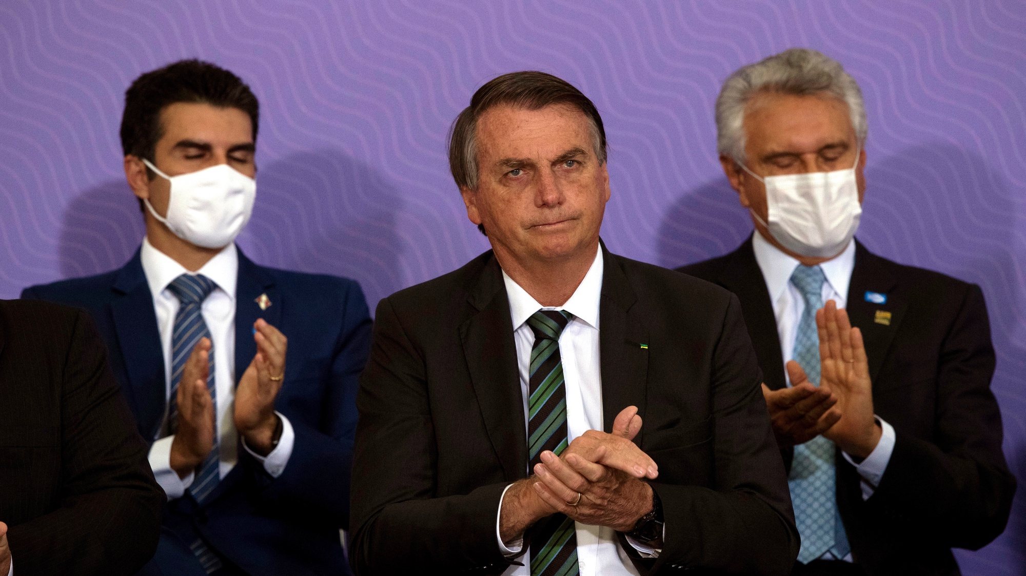 epa08887787 Brazilian President Jair Bolsonaro (C) applauds during the launch of the National Vaccination Plan against covid-19, at the Planalto Palace in Brasilia, Brazil, 16 December 2020. The Brazilian Government presented the master lines of its future vaccination plan against covid-19, which plans to immunize 210 million inhabitants in about 16 months, but has not yet set a start date for the process. According to the Ministry of Health, to establish the day on which the first of the five planned vaccination phases will begin, one must wait for an vaccine to be approved and registered by the National Health Surveillance Agency (Anvisa), which could occur for next February.  EPA/Joedson Alves