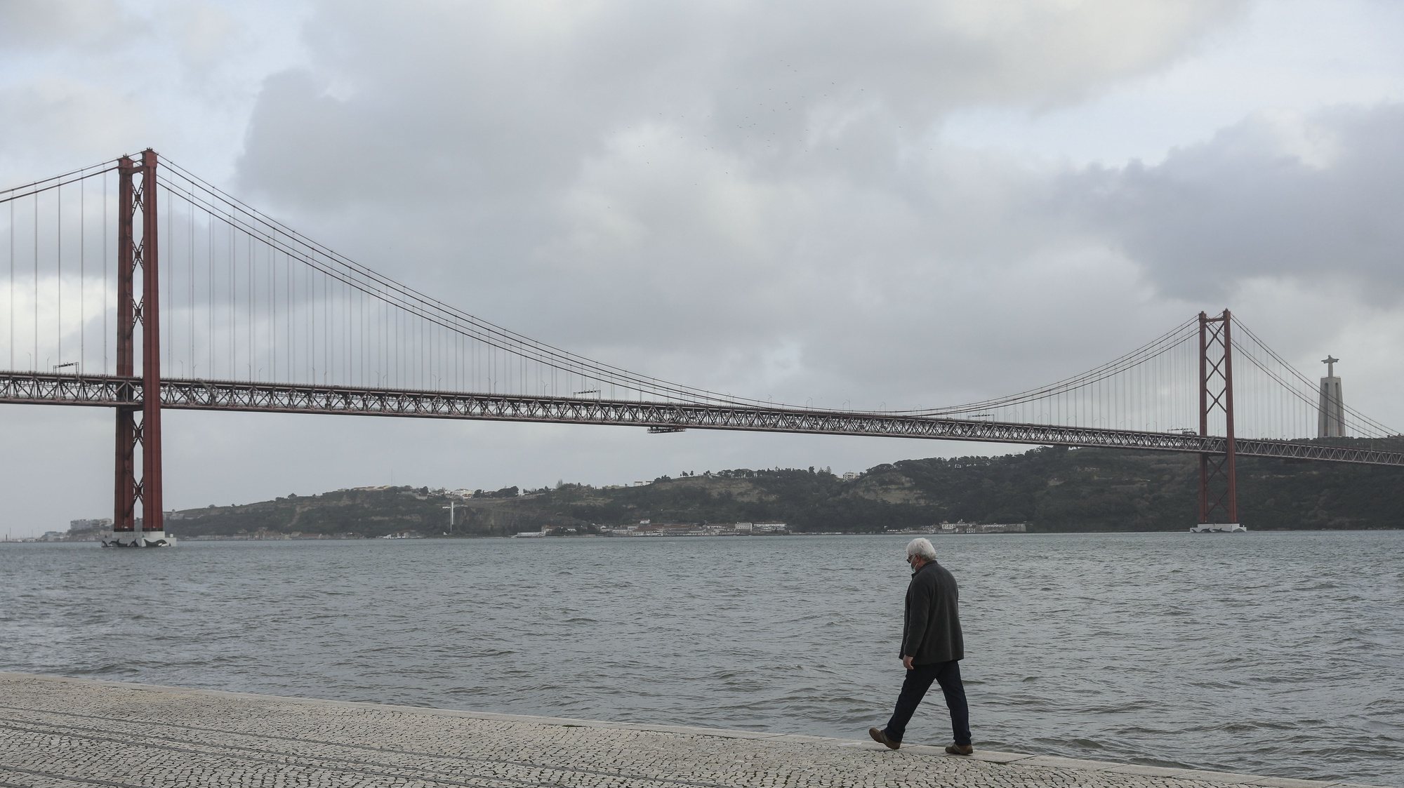 Um homem passeia junto ao rio Tejo em Lisboa, durante período com medidas de restrição impostas pelo novo confinamento, na sequência da pandemia de Covid-19, 30 de janeiro de 2021. MIGUEL A. LOPES/LUSA