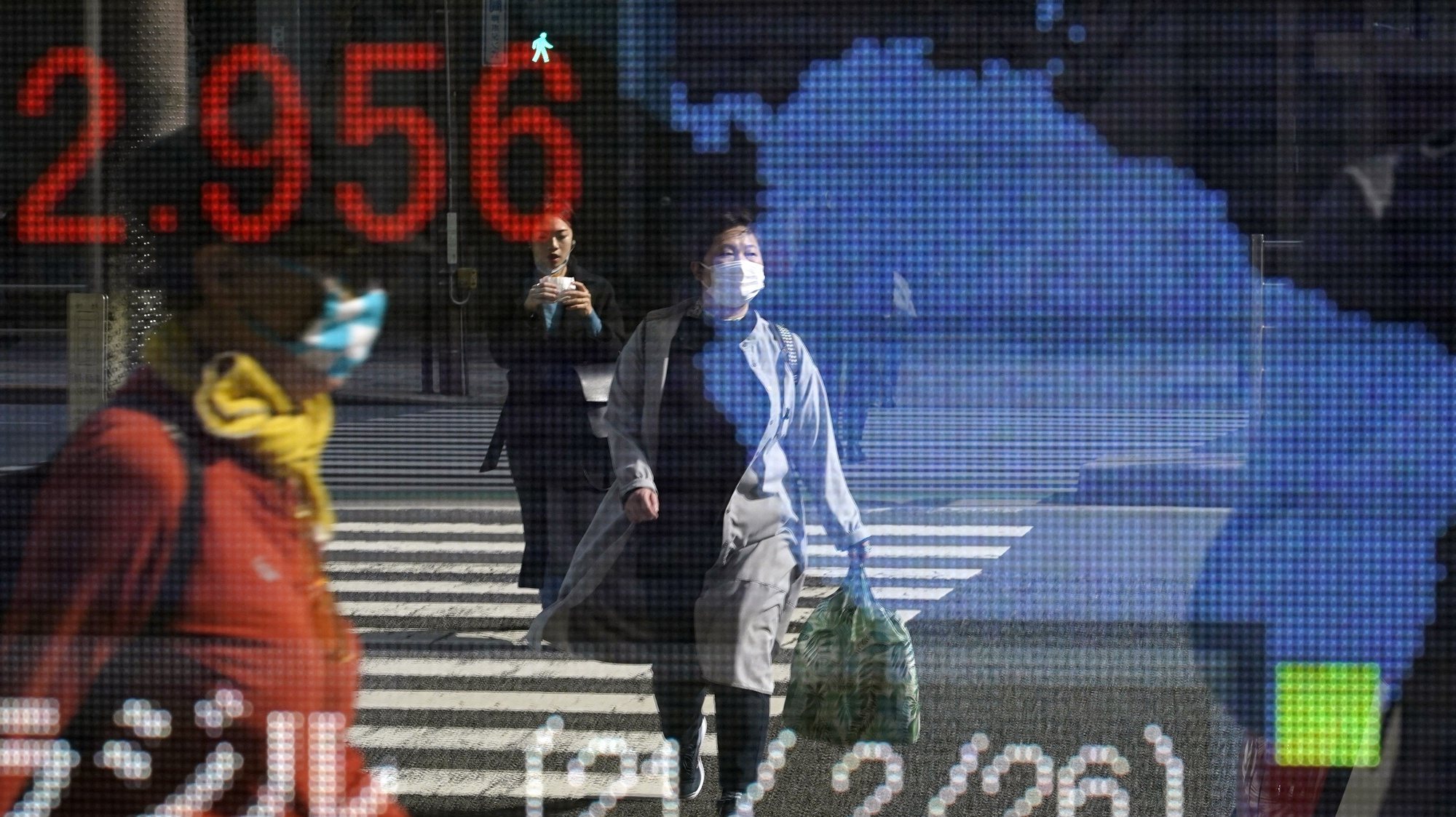 epaselect epa09044114 Passersby are reflected in a stock market indicator board in Tokyo, Japan, 01 March 2021. Tokyo stocks rebounded sharply at the start of the week following its large drop on 26 February. The 225-issue Nikkei Stock Average gained 697.49 points, or 2.41 per cent, to close at 29,663.50.  EPA/FRANCK ROBICHON