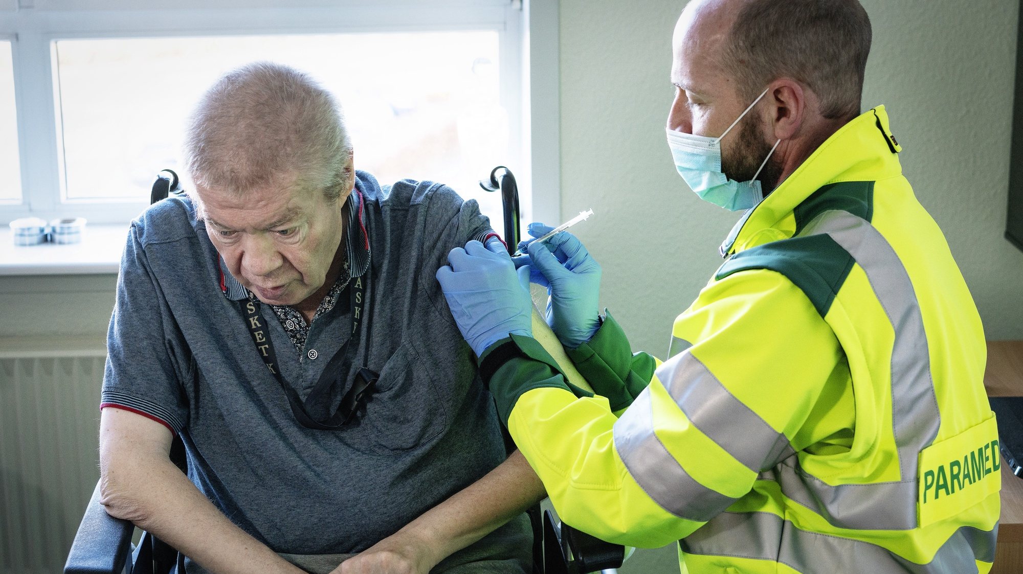 epa09053200 A 67-year-old Aage Steen Jensen, who is a kidney patient, is vaccinated in his own home in Aalborg, Denmark, 05 March 2021. Elderly, over 65, who cannot be transported to a coronavirus vaccination site, receive both practical help and personal care. On 05 March, the first seven persons from Northern Jutland will receive the first vaccinations against Covid-19 in their own homes. Paramedics from the North Jutland Region will perform the vaccinations.  EPA/BO AMSTRUP  DENMARK OUT