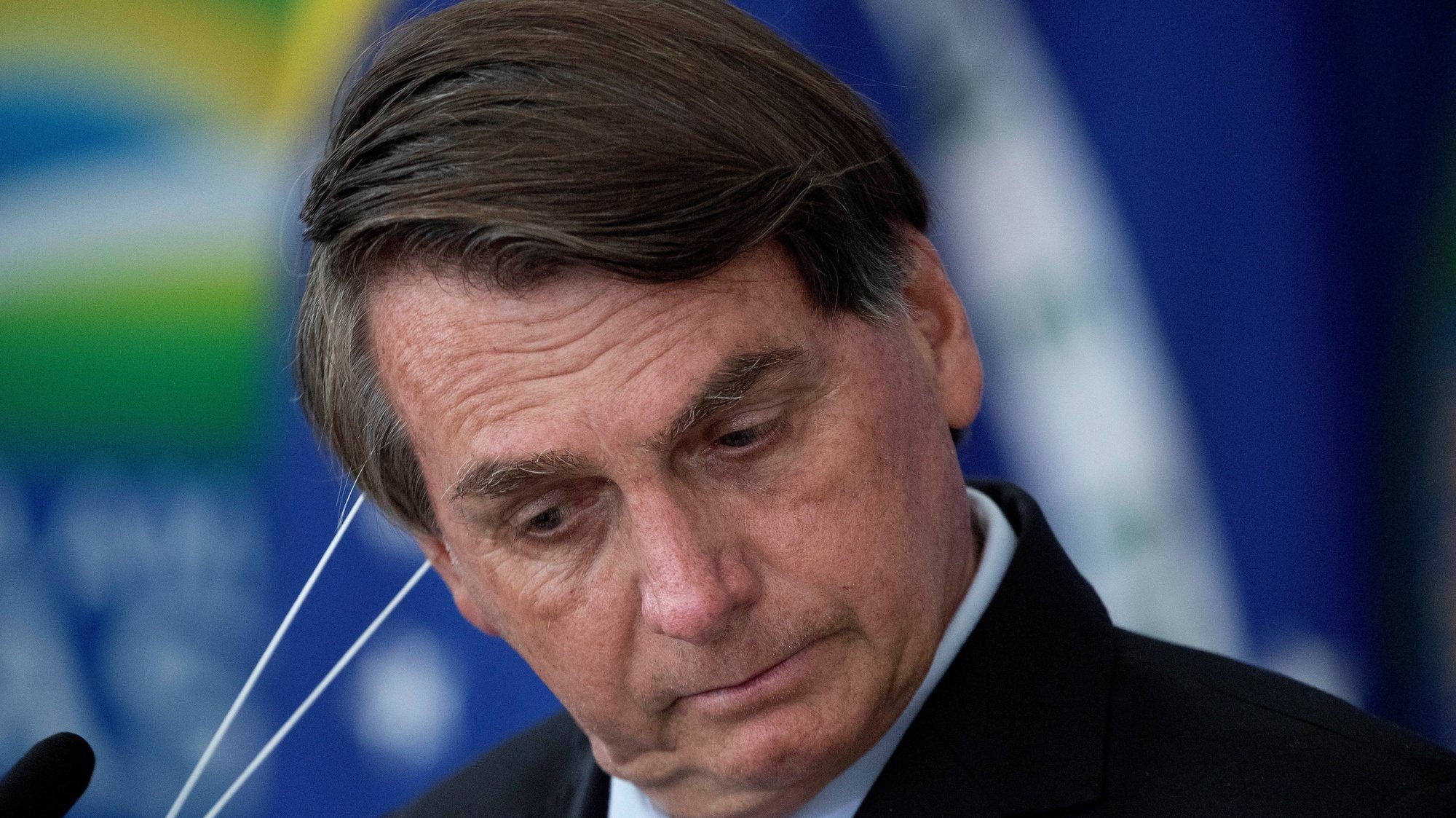 epa09066297 Brazilian President Jair Bolsonaro removes his mask during the signing ceremony of bills to expand the capacity to purchase vaccines by the Federal Government, at the Planalto Palace, in Brasilia, Brazil, 10 March 2020.  EPA/Joedson Alves