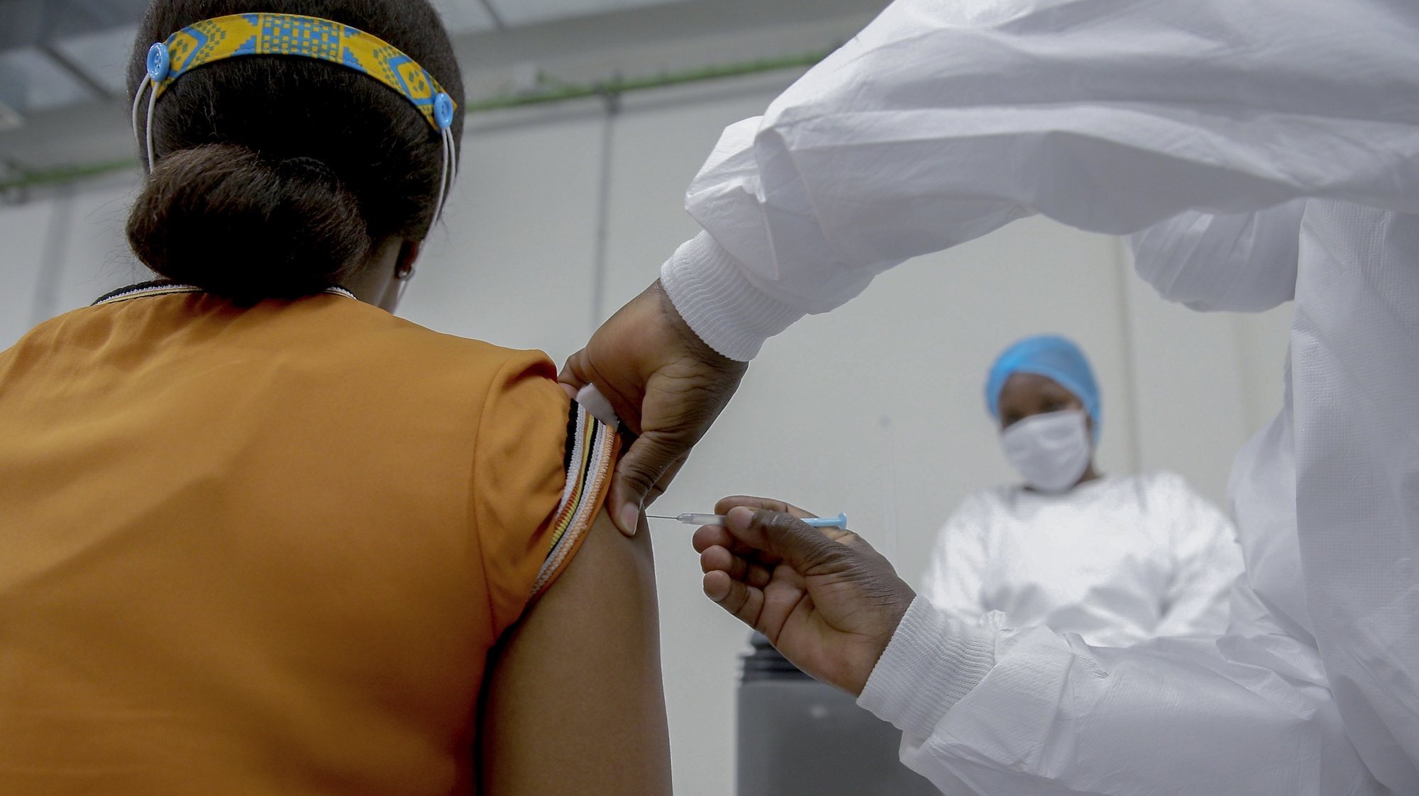 Uma mulher é vacinada na sala de vacinação do depósito central de vacinas de Angola, no dia em que chegaram ao país as primeiras 624.000 doses de vacinas contra a covid-19, no aeroporto Internacional 4 de Fevereiro, que contou com a presença da ministra da Saúde, Silvia Lutucuta (ausente da foto), no âmbito da iniciativa Covax, Luanda, Angola, 2 de março de 2021. AMPE ROGÉRIO/LUSA
