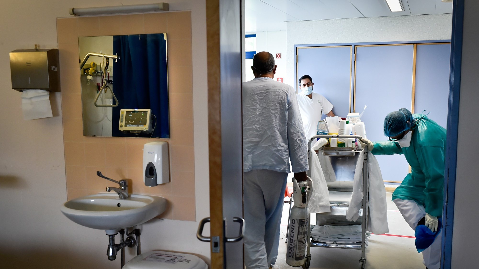Um operacional de saúde auxilia um doente infetado com coronavírus (covid-19) durante o turno de trabalho na enfermaria do piso 7 do Centro Hospitalar Tondela Viseu (CHTV), dedicado ao tratamento de doentes com covid-19, em Viseu, 09 de março de 2021. (ACOMPANHA TEXTO DA LUSA DO DIA 10 DE MARÇO DE 2021). NUNO ANDRÉ FERREIRA/LUSA