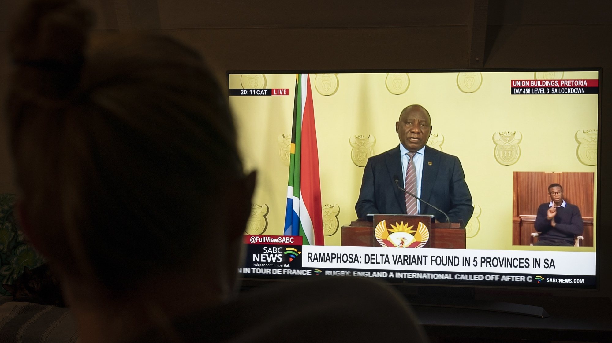 epa09306317 A South African watches a live television broadcast of President Cyril Ramaphosa announcing new restrictions in an attempt to slow a third wave of Covid-19 across the country, in Cape Town, South Africa, 27 June 2021. South African President Ramaphosa announced the country will move to adjusted alert level 4 with travel in and out of the epicenter Gauteng Province restricted as the country struggles to contain a third wave with a rapidly spreading Delta variant of the Sars-Cov-2 coronavirus that causes the Covid-19 disease.  EPA/NIC BOTHMA
