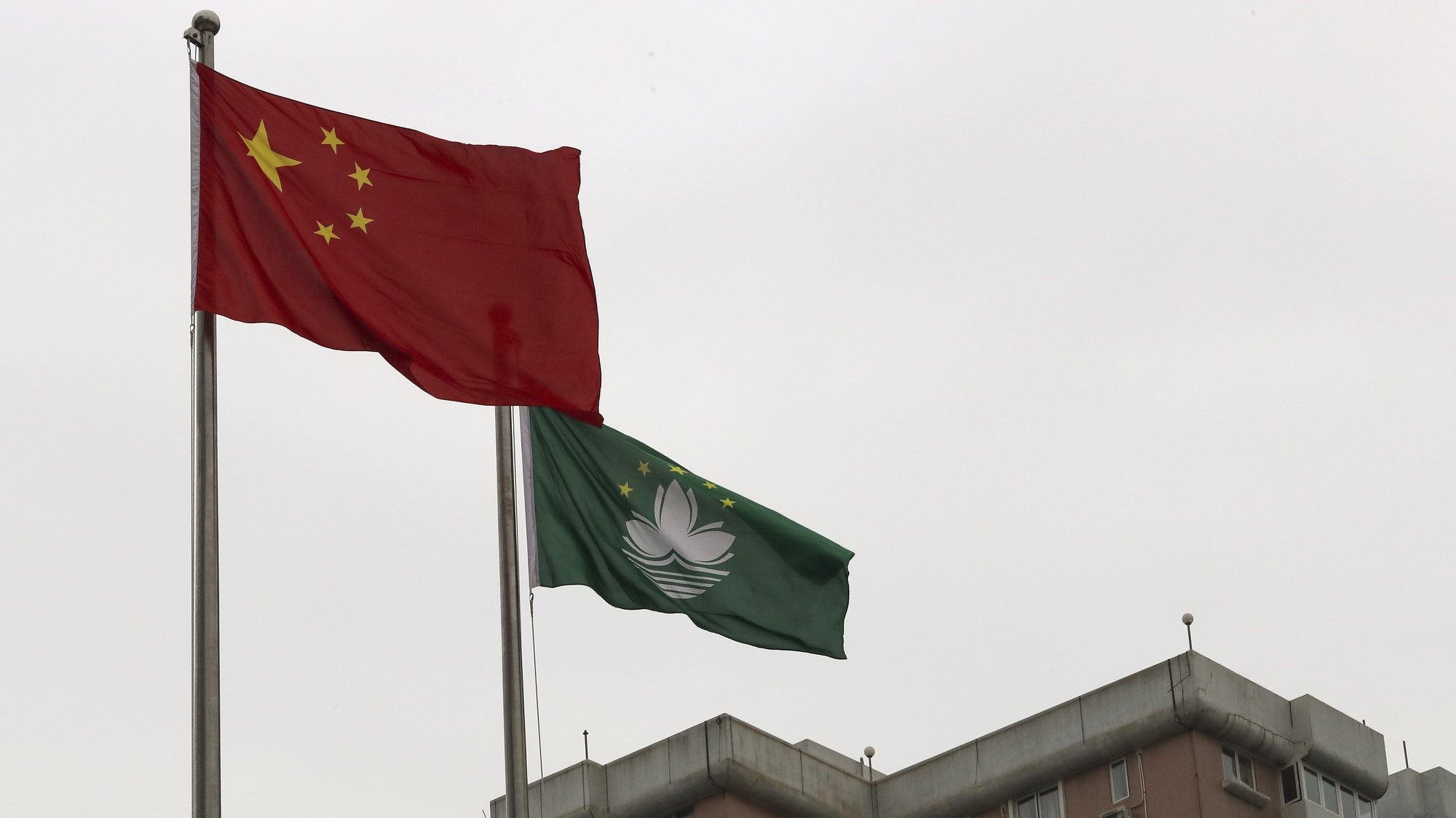 epa08082673 Chinese and Macao&#039;s flags wave during the flag-raising ceremony for Macao Special Administrative Region&#039;s (SAR) 20th anniversary at Lotus Flower Square in Macao, China, 20 December 2019. Macao had been a Portuguese colony until 1999 when it returned to Chinese rule under the &#039;one country, two systems&#039; principle.  EPA/JOAO RELVAS