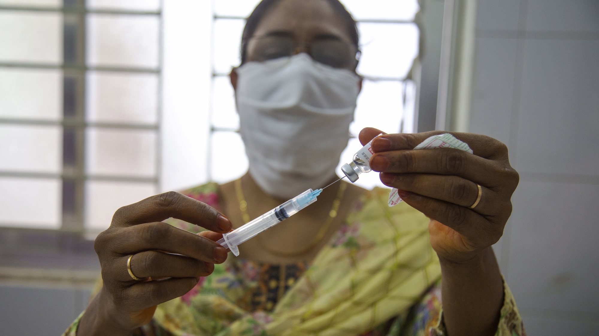 epa09397425 A health worker prepares a dose of the Sinopharm COVID19 vaccine during a vaccination campaign at the Keraniganj Upazila Health Complex on the outskirts of Dhaka, Bangladesh, 05 August 2021. According to the Bangladesh Directorate General of Health Services (DGHS), the nationwide mass vaccination program will be starting on 14 August. Bangladesh has recorded nearly 1.31 million coronavirus infections and 21,638 fatalities since the pandemic began.  EPA/MONIRUL ALAM