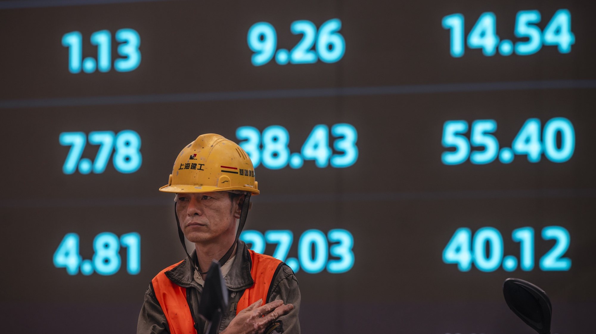 epa09510804 A worker stands in front of the screen showing newest stock exchange and economic data in Shanghai, China, 07 October 2021. A debt crisis and rising bond yields of China Evergrande Group made a whirlwind for other Chinese real estate developers who suspended their stock trading this week in the Hong Kong market. There are concerns and speculations in the Hong Kong stock market over the uncertainty and market value.  EPA/ALEX PLAVEVSKI